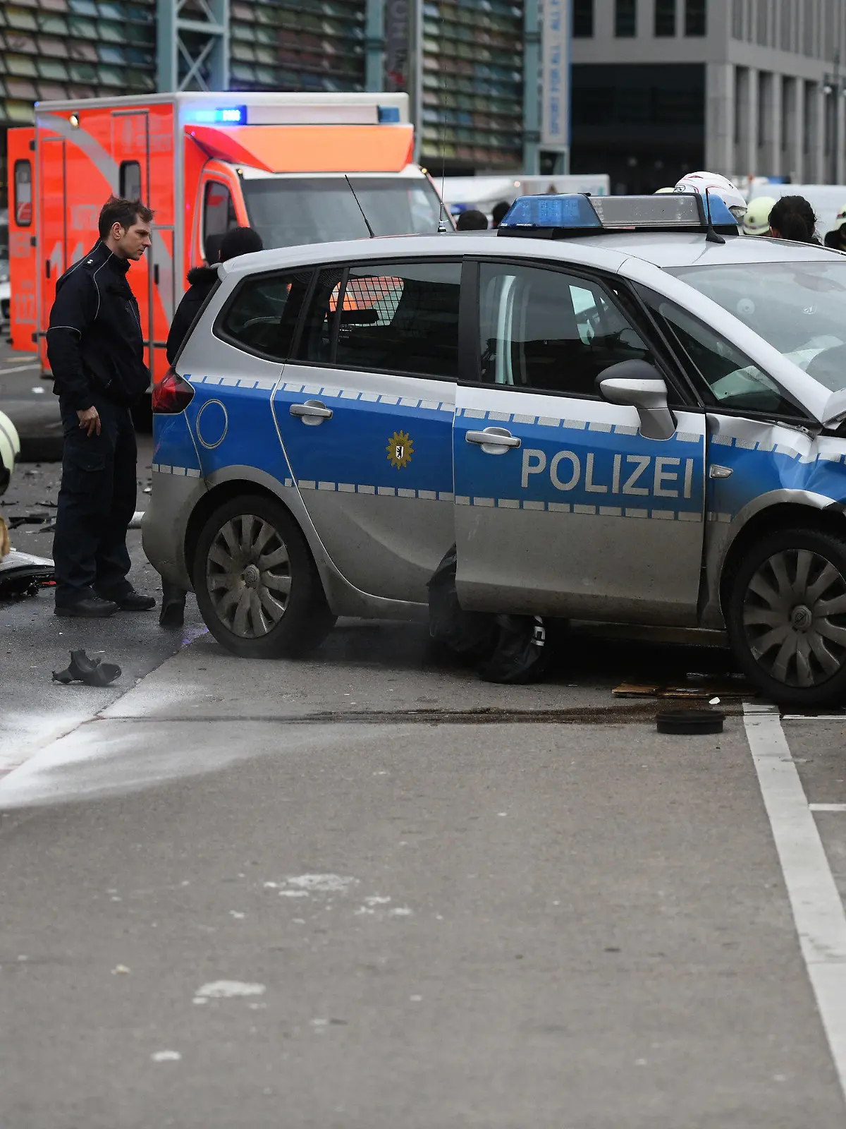 ARCHIV - 29.01.2018, Berlin: Ein Polizist und Feuerwehrmänner arbeiten an einem Unfallort, an dem ein Polizeifahrzeug während eines Einsatzes mit einem weiteren Auto zusammenprallte. (zu dpa «Tödlicher Unfall mit Polizeiwagen - Beamter war alkoholisiert») Foto: Maurizio Gambarini/dpa +++ dpa-Bildfunk +++