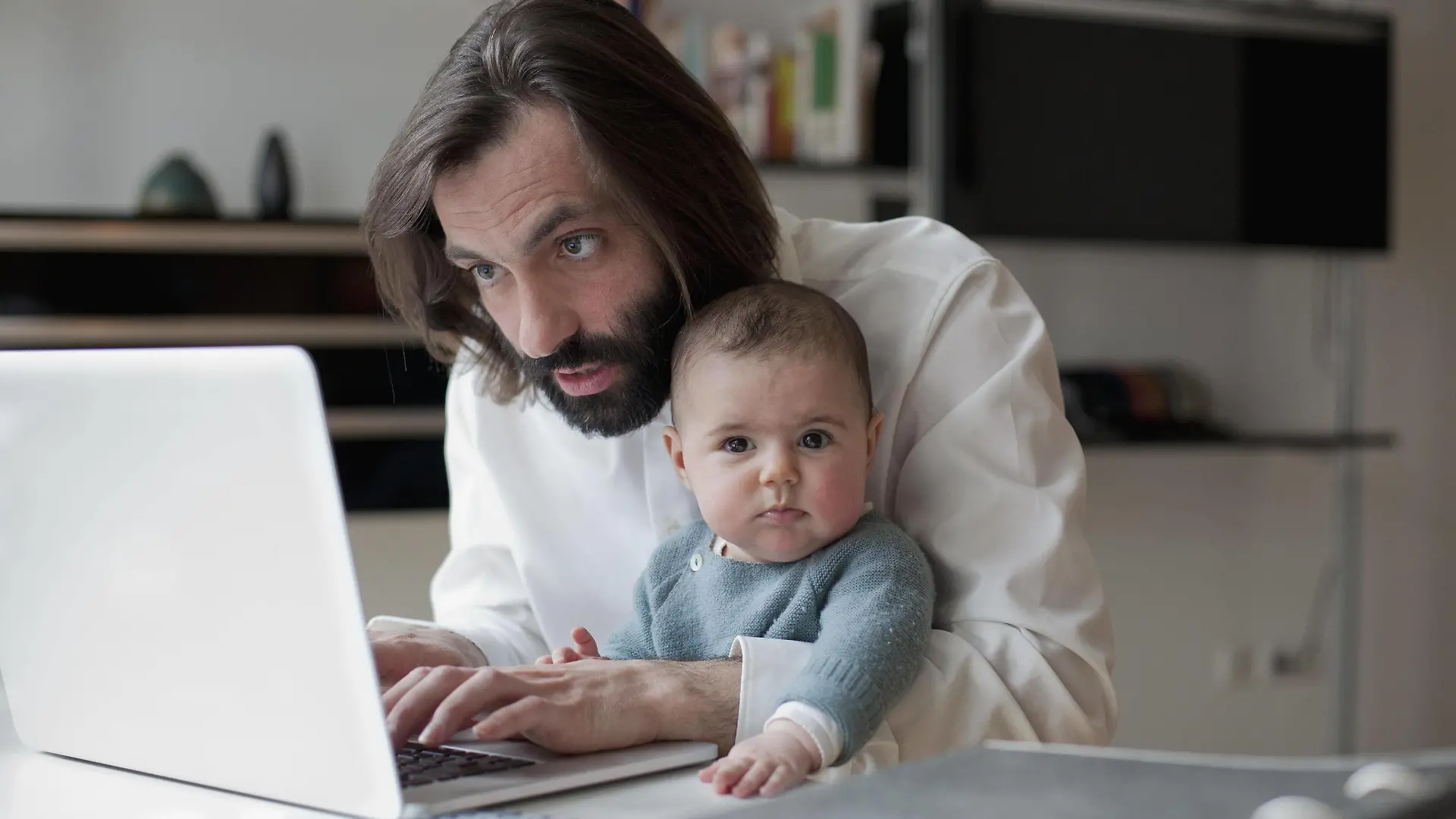  Man working on laptop while sitting with baby girl at home PUBLICATIONxINxGERxSUIxAUTxONLY Copyright: Antenna fStopImages1331040