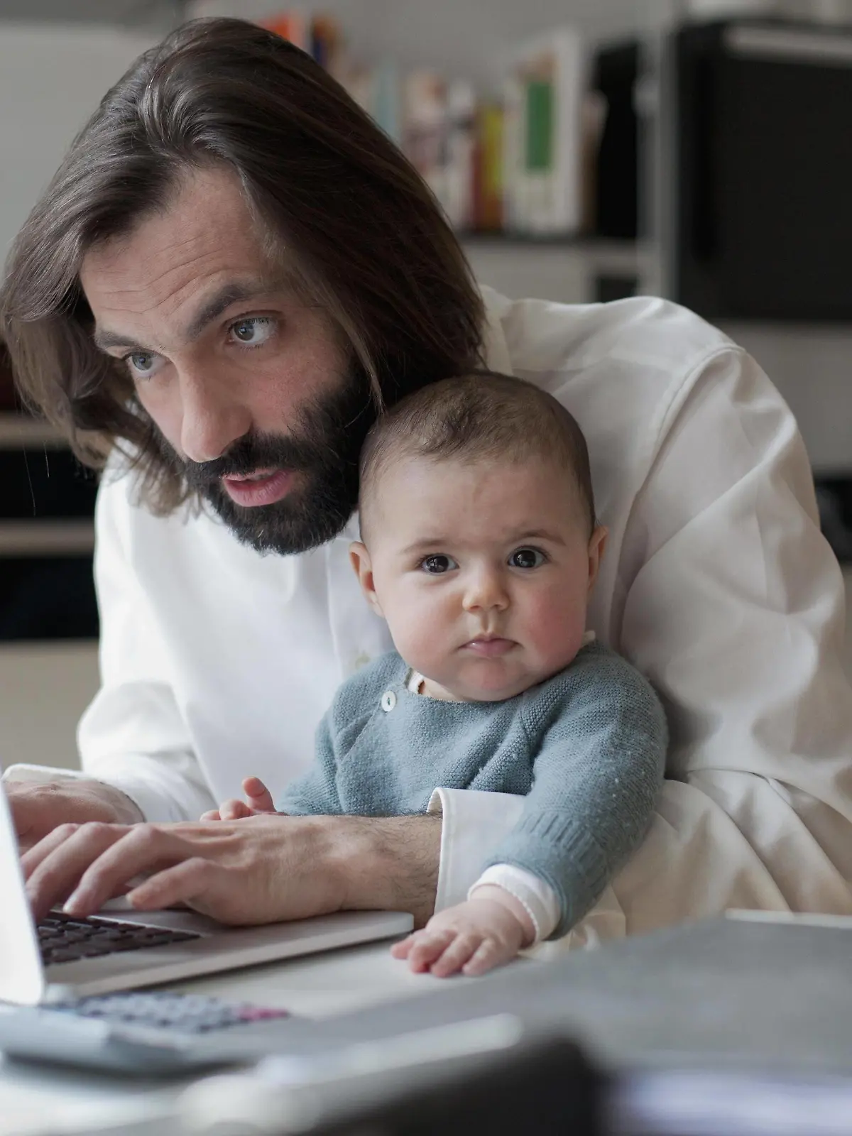  Man working on laptop while sitting with baby girl at home PUBLICATIONxINxGERxSUIxAUTxONLY Copyright: Antenna fStopImages1331040