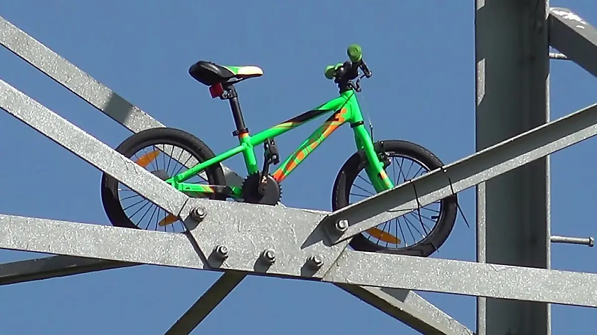 Ein Fahrrad wurde mit Kabelbindern an diesen Strommast befestigt.