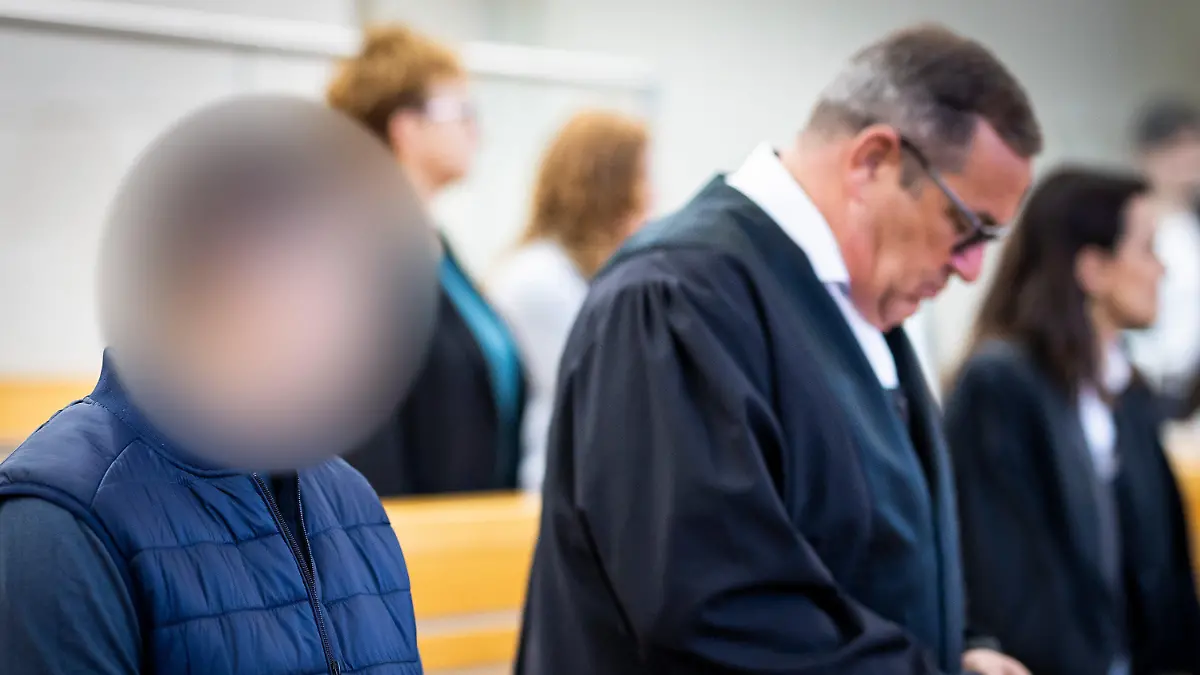 06.04.2023, Niedersachsen, Hannover: Die beiden Angeklagten (l und 3.v.l.) stehen im Gerichtssaal im Landgericht. Eine Frau und ein Mann sind wegen Mordes angeklagt, weil sie den Unfalltod von zwei kleinen Jungen verursacht haben sollen. Beiden wird vorgeworfen, sich auf einer Landstraße bei Barsinghausen ein verbotenes Autorennen geliefert zu haben. Dabei kam es zu Zusammenstößen mit entgegenkommenden Autos. Foto: Moritz Frankenberg/dpa - ACHTUNG: Angeklagter auf Anweisung des Gerichts gepixelt +++ dpa-Bildfunk +++