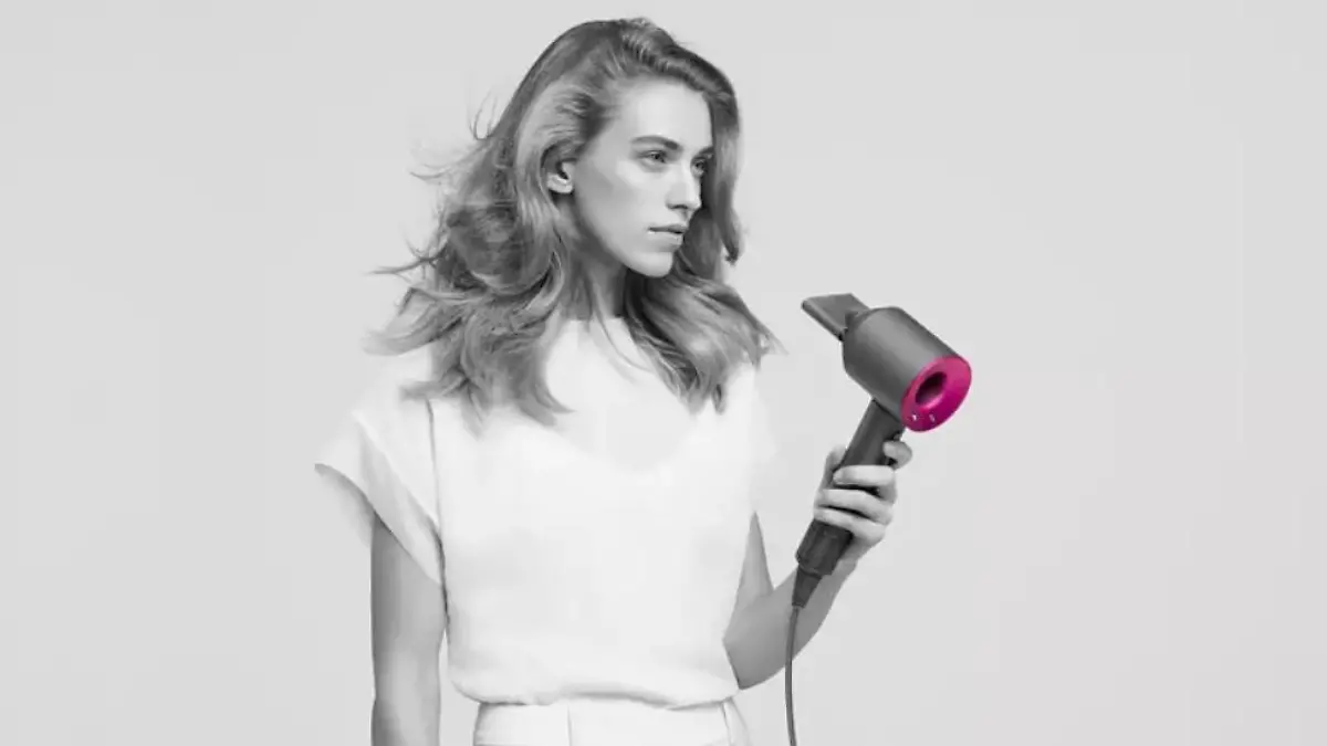 Dyson Supersonic: Frau hält den Haartrockner in der Hand.