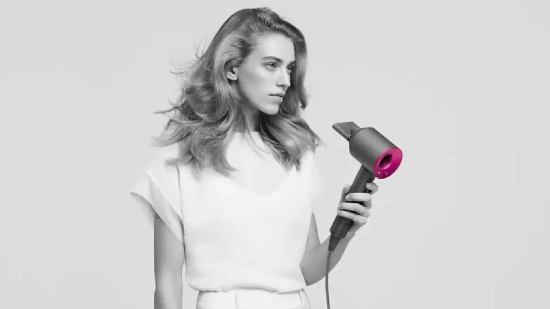 Dyson Supersonic: Frau hält den Haartrockner in der Hand.