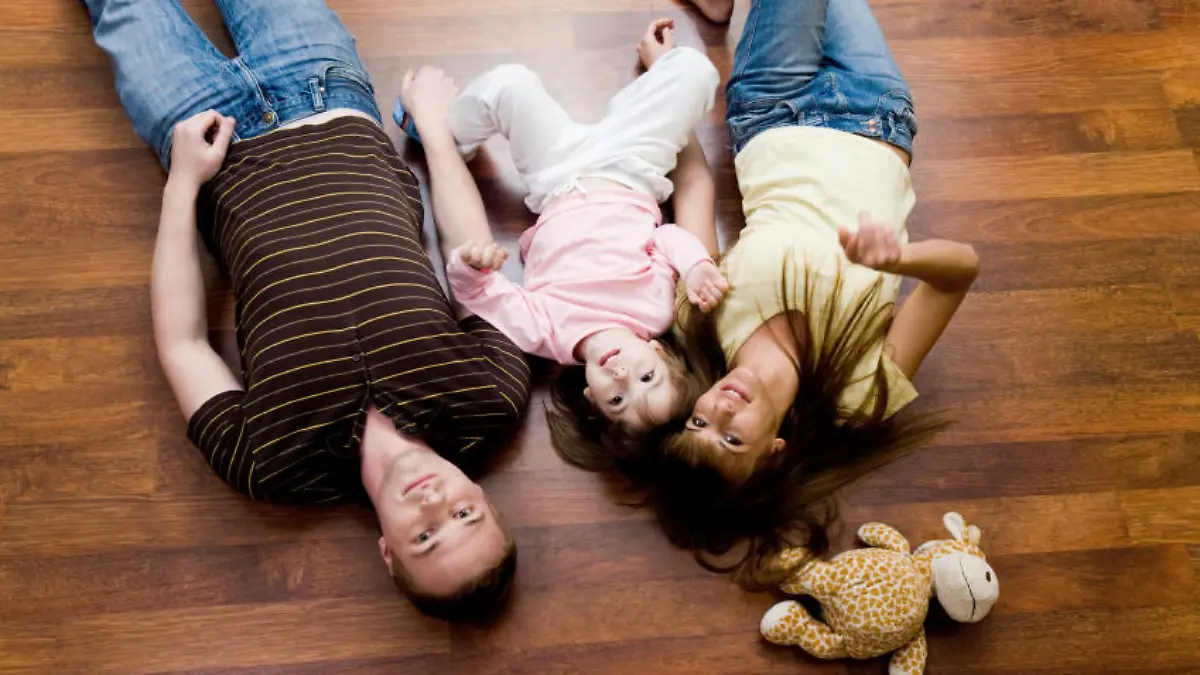 View from above of resting family lying on the floor and looking at camera