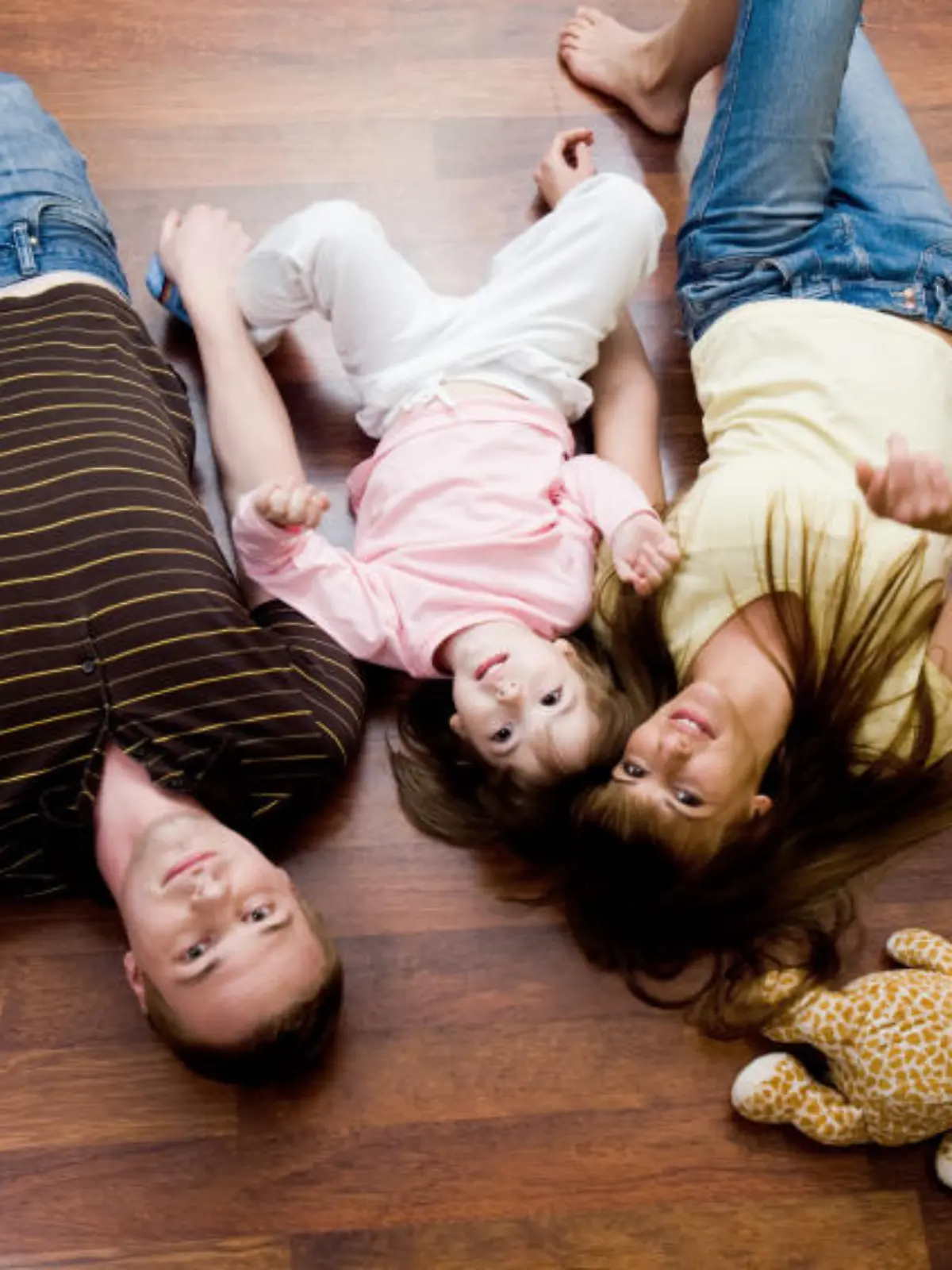View from above of resting family lying on the floor and looking at camera