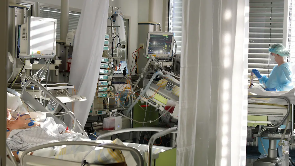 24.11.2020, Sachsen, Leipzig: Auf der Covid-19-Station, einem Bereich der Operativen Intensivstation vom Universitätsklinikum Leipzig, versorgt eine Intensivkrankenschwester schwerkranke Patienten. Auf der Intensivstation wächst seit Tagen die Zahl der Corona-Erkrankten mit schweren Verläufen, darunter immer mehr jüngere Patenten zwischen 30 und 60 Jahren. Foto: Waltraud Grubitzsch/dpa-Zentralbild/dpa +++ dpa-Bildfunk +++