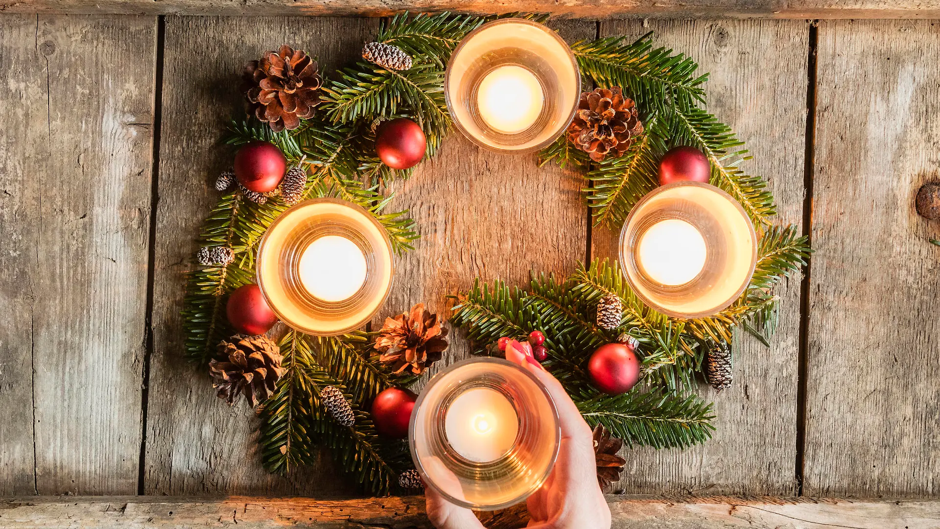 Hand of woman touching glass cover of candle burning on Advent wreath model released Symbolfoto EVGF03704