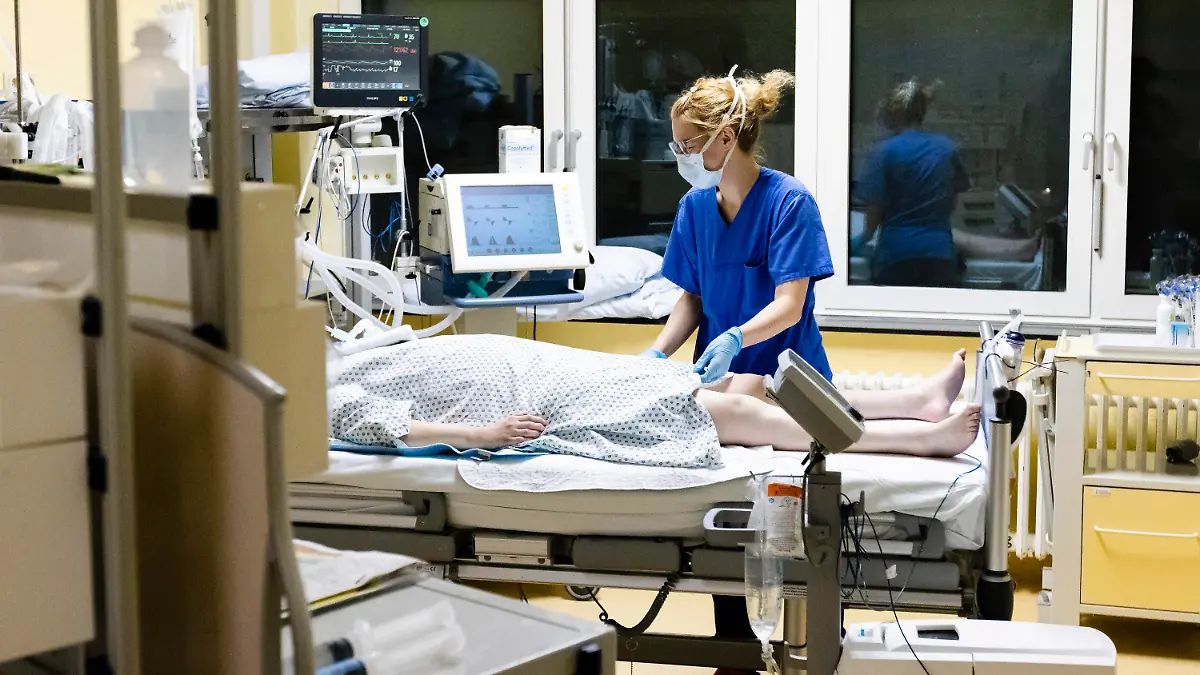 03.12.2020, Schleswig-Holstein, Kiel: Melina Lütje, Krankenschwester auf der Intensivstation am Universitätsklinikum Schleswig-Holstein, steht am Bett einer Patientin. Die Zahl der Corona-Patienten auf deutschen Intensivstationen hat erstmals die Schwelle von 4000 überschritten. Am Freitag meldete die Deutsche Interdisziplinären Vereinigung für Intensiv- und Notfallmedizin (Divi) 4011 Menschen in intensivmedizinischer Behandlung. Das waren 31 mehr als am Vortag, wie aus dem DIVI-Tagesbericht hervorgeht. 60 Prozent der Patienten werden invasiv beatmet (Stand: 04.12., 12.15 Uhr). Foto: Frank Molter/dpa +++ dpa-Bildfunk +++