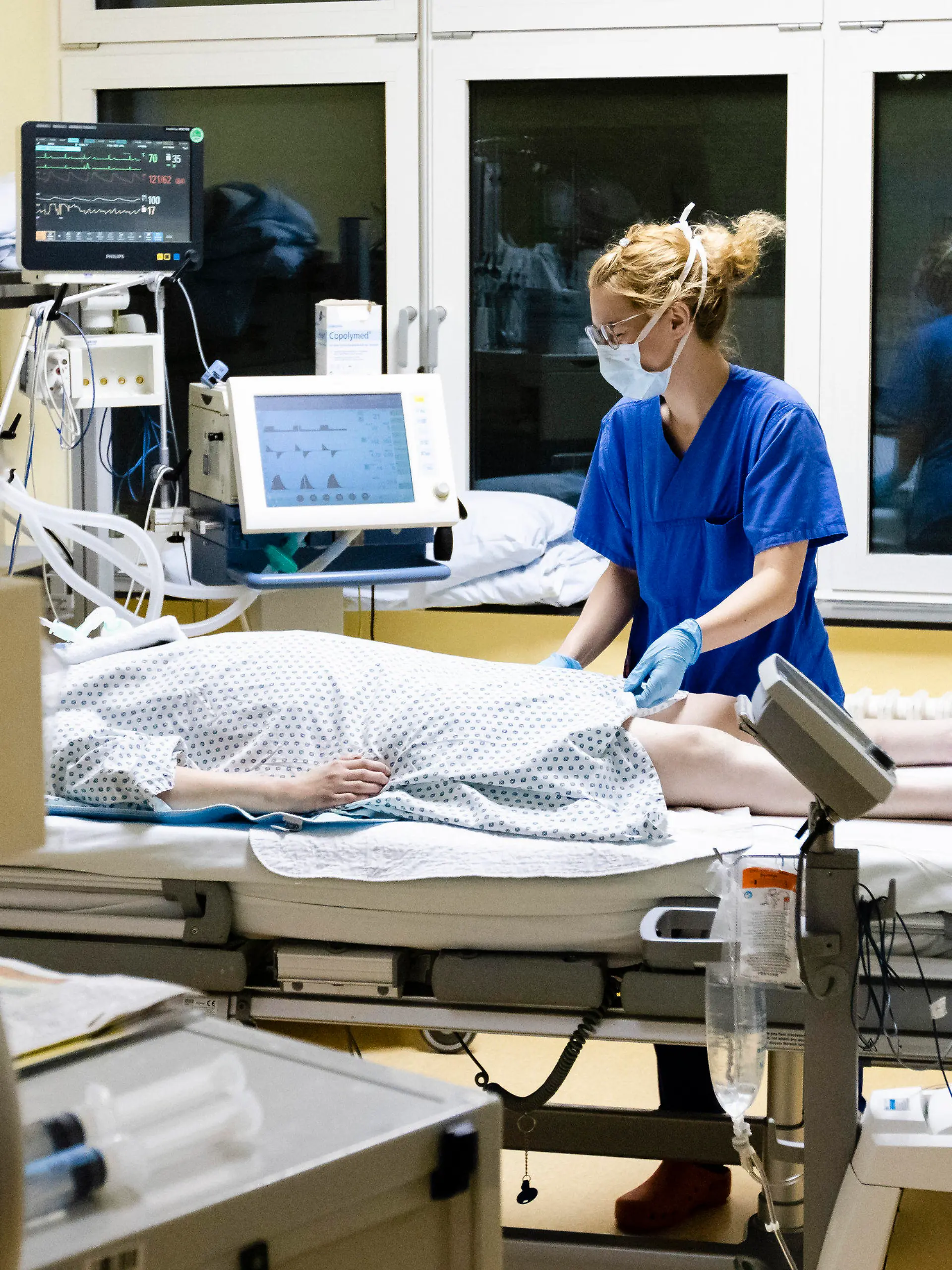 03.12.2020, Schleswig-Holstein, Kiel: Melina Lütje, Krankenschwester auf der Intensivstation am Universitätsklinikum Schleswig-Holstein, steht am Bett einer Patientin. Die Zahl der Corona-Patienten auf deutschen Intensivstationen hat erstmals die Schwelle von 4000 überschritten. Am Freitag meldete die Deutsche Interdisziplinären Vereinigung für Intensiv- und Notfallmedizin (Divi) 4011 Menschen in intensivmedizinischer Behandlung. Das waren 31 mehr als am Vortag, wie aus dem DIVI-Tagesbericht hervorgeht. 60 Prozent der Patienten werden invasiv beatmet (Stand: 04.12., 12.15 Uhr). Foto: Frank Molter/dpa +++ dpa-Bildfunk +++