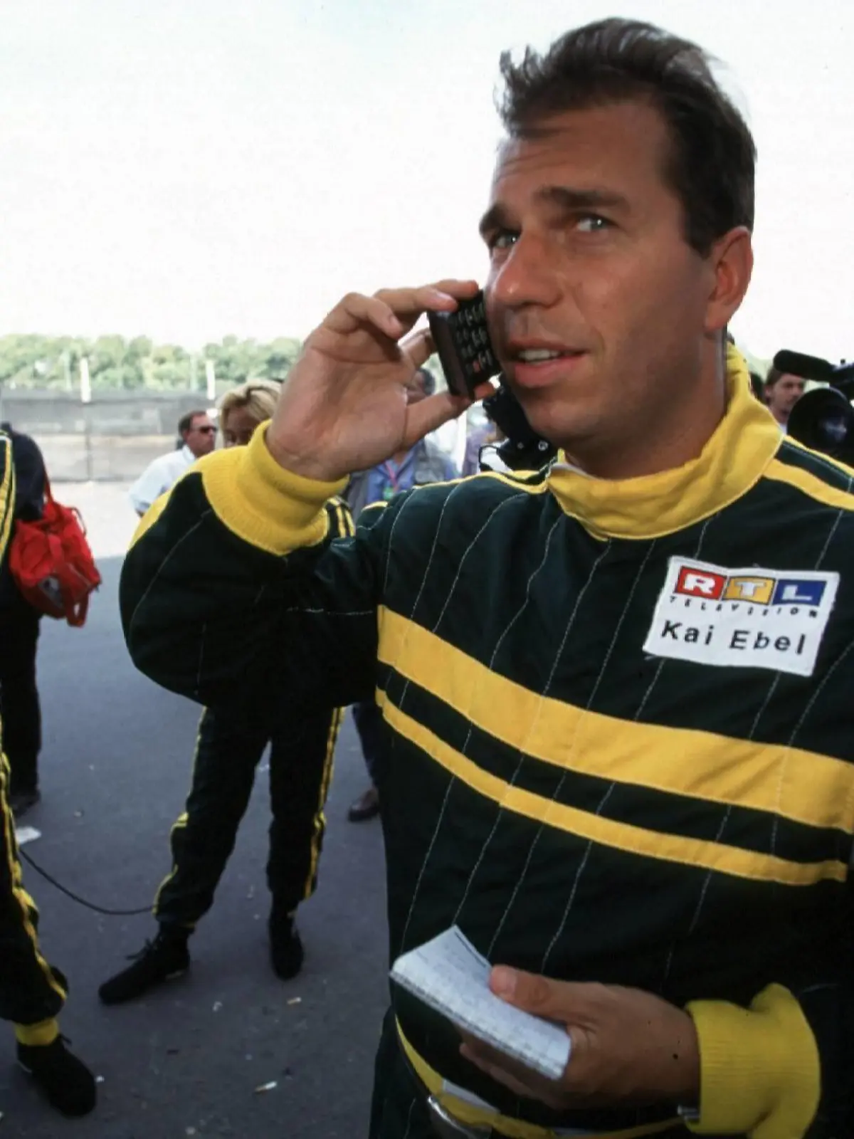  RTL-Moderator Kai Ebel mit Handy telefonierend in der Boxengasse