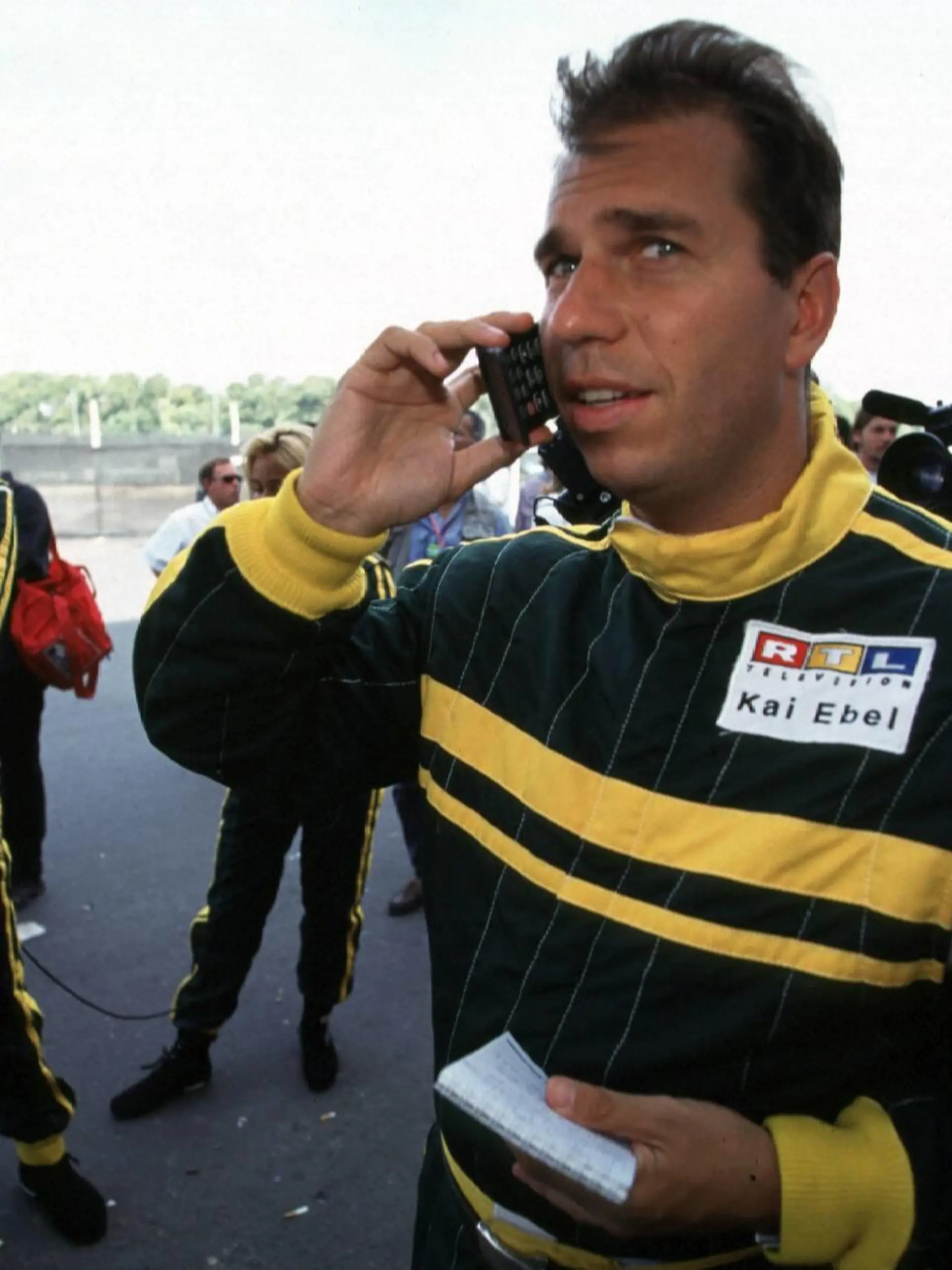  RTL-Moderator Kai Ebel mit Handy telefonierend in der Boxengasse