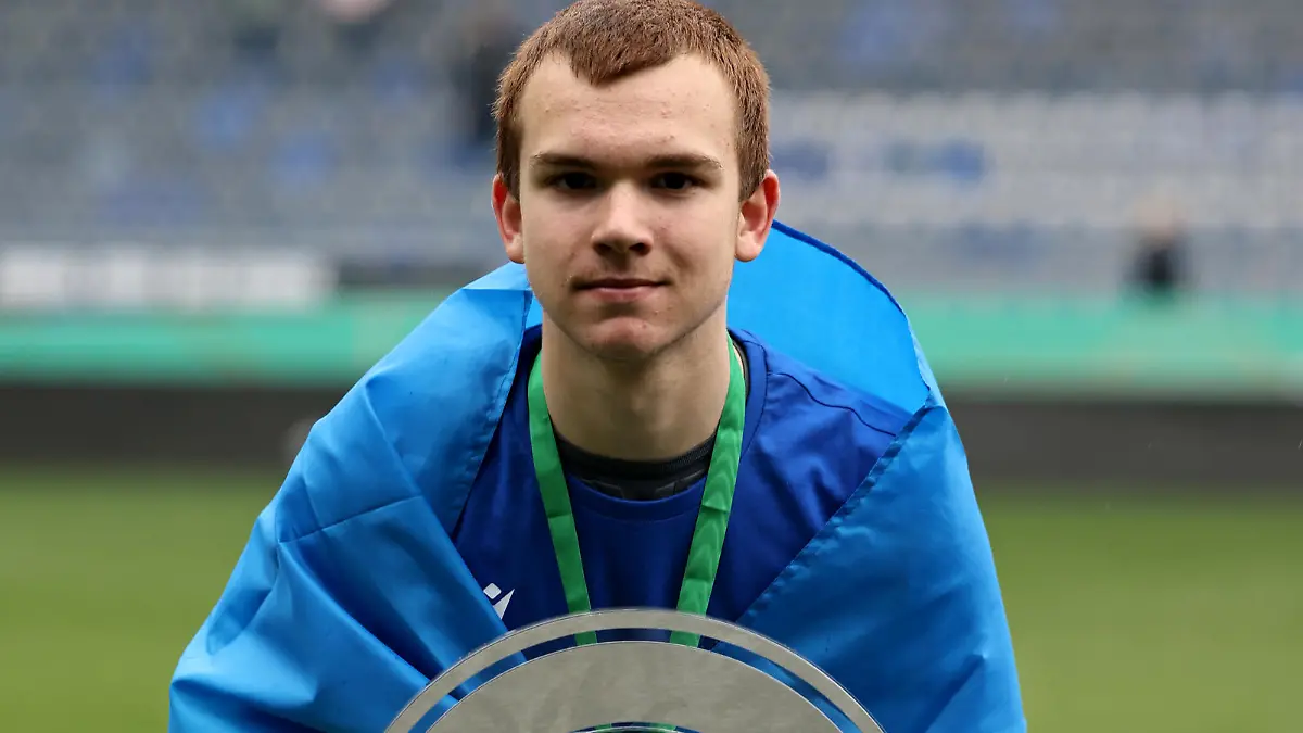 BIELEFELD, GERMANY - APRIL 16: Artem Zaloha of Bielefeld celebrates with the trophy after winning 2-1 the B Juniors German Championship Final between Arminia Bielefeld and VfL Wolfsburg at Schueco Arena on April 16, 2023 in Bielefeld, Germany. (Photo by Christof Koepsel/Getty Images)