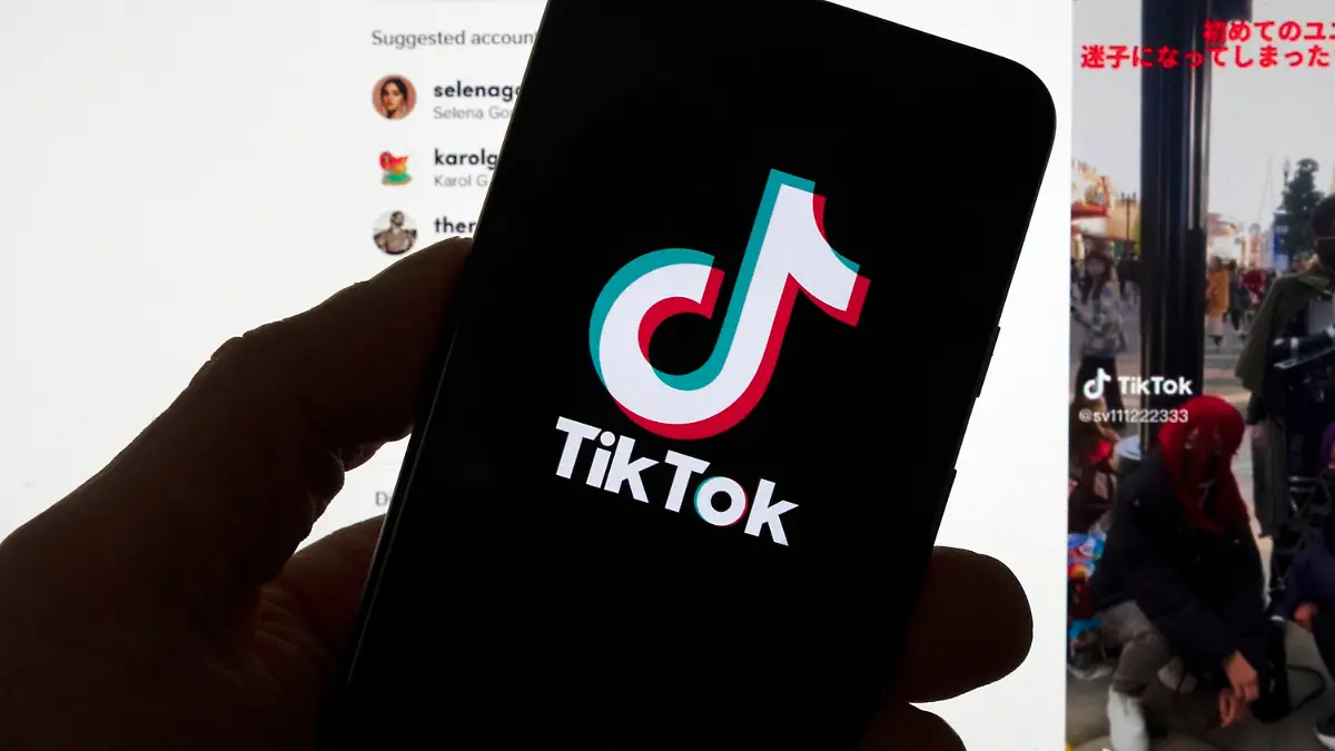FILE - The TikTok logo is seen on a mobile phone in front of a computer screen which displays the TikTok home screen, March 18, 2023, in Boston. Social media platforms often rely on labels to let users know an account is operated by a Russian state propaganda agency. But new research shows that on TikTok at least, the labels aren't very effective even when they're applied consistently. (AP Photo/Michael Dwyer, File)