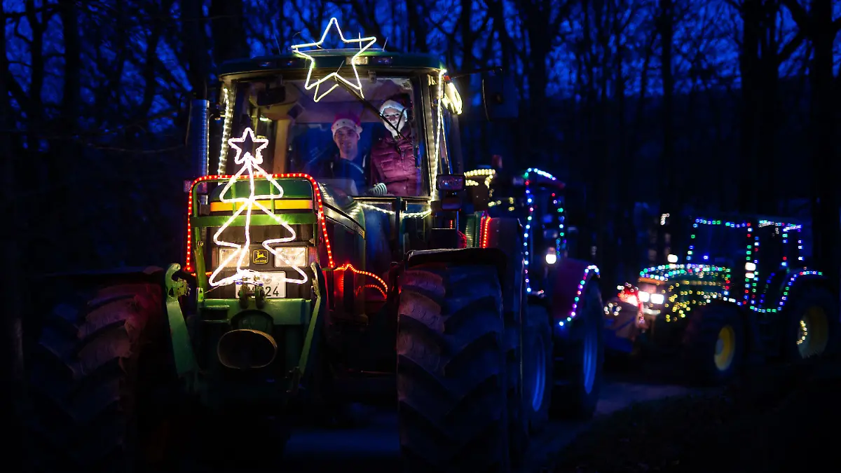 05.12.2020, Nordrhein-Westfalen, Lüdenscheid: Katrin Abel (r) und Jonas Lichtlinghagen sitzen in ihrem weihnachtlich geschmückten Trecker in der Nähe des SOS Kinderdorfs. Landwirte wollen mit Hunderten weihnachtlich beleuchteten Treckern in vielen Teilen von NRW für kleine Lichtblicke in der Pandemie sorgen. Die Aktion am Nikolausvorabend steht unter dem Motto «Ein Funke Hoffnung». Foto: Jonas Güttler/dpa +++ dpa-Bildfunk +++