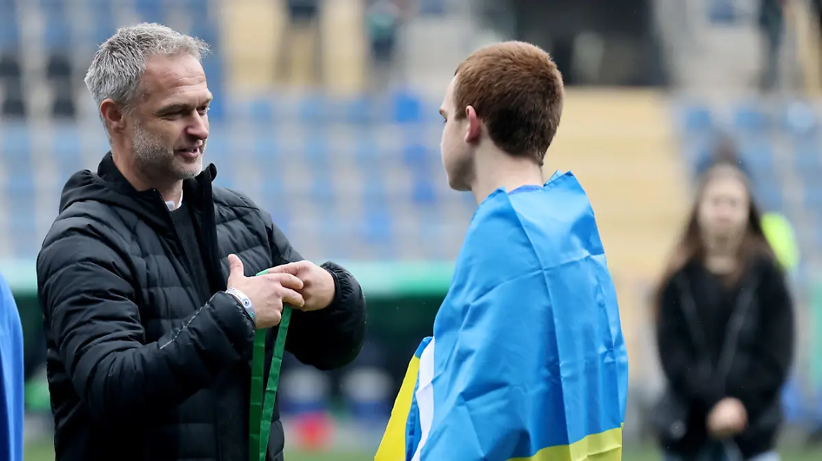 BIELEFELD, GERMANY - APRIL 16: Christian Wueck, national coach U17 Germany hands out the gold medal to Artem Zaloha of Bielefeld on the podium after the B Juniors German Championship Final between Arminia Bielefeld and VfL Wolfsburg at Schueco Arena on April 16, 2023 in Bielefeld, Germany. (Photo by Christof Koepsel/Getty Images)