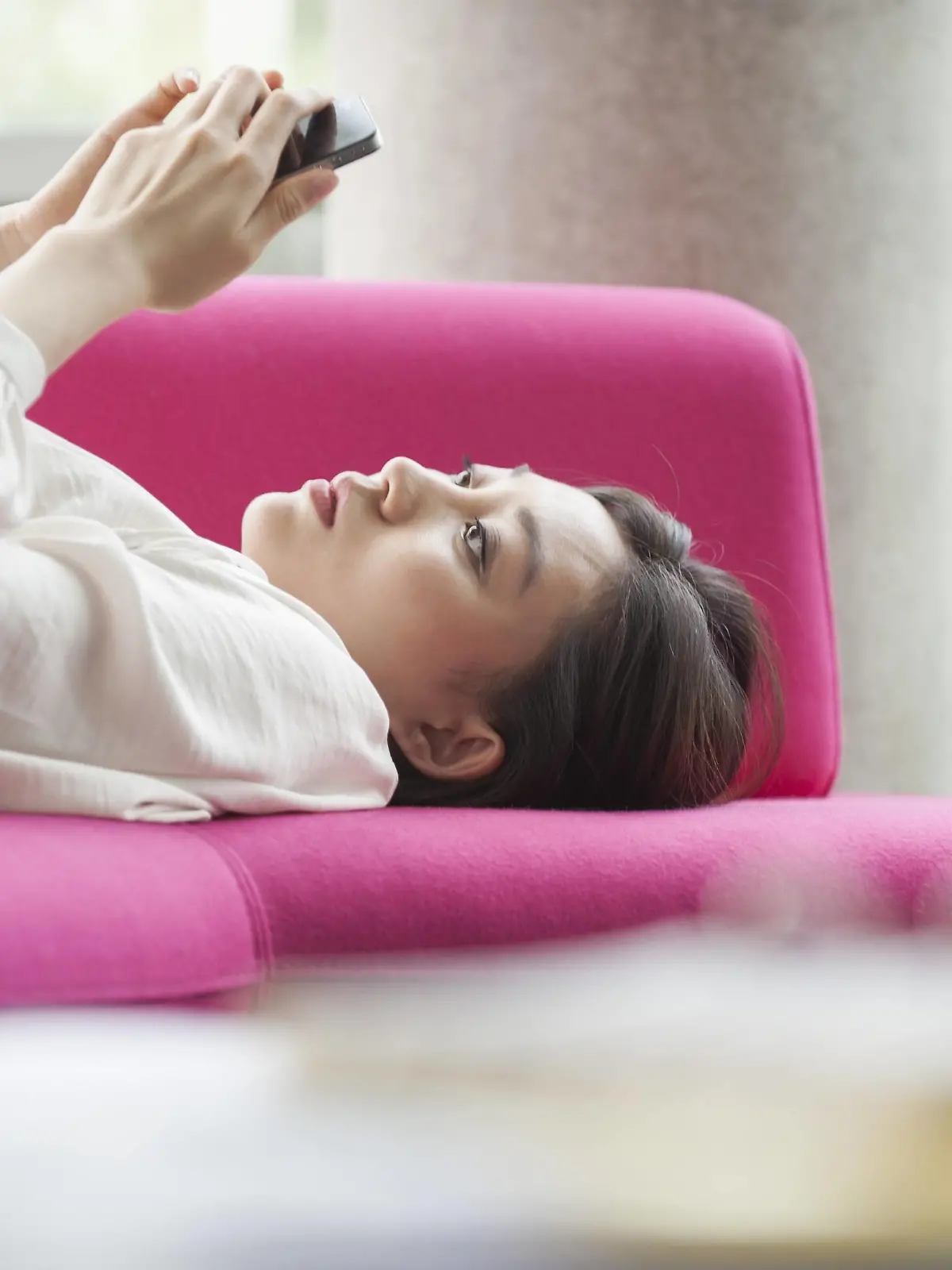 Woman relaxing at home using smartphone PUBLICATIONxINxGERxSUIxAUTxONLY Copyright: OdilonxDimier B27279227  