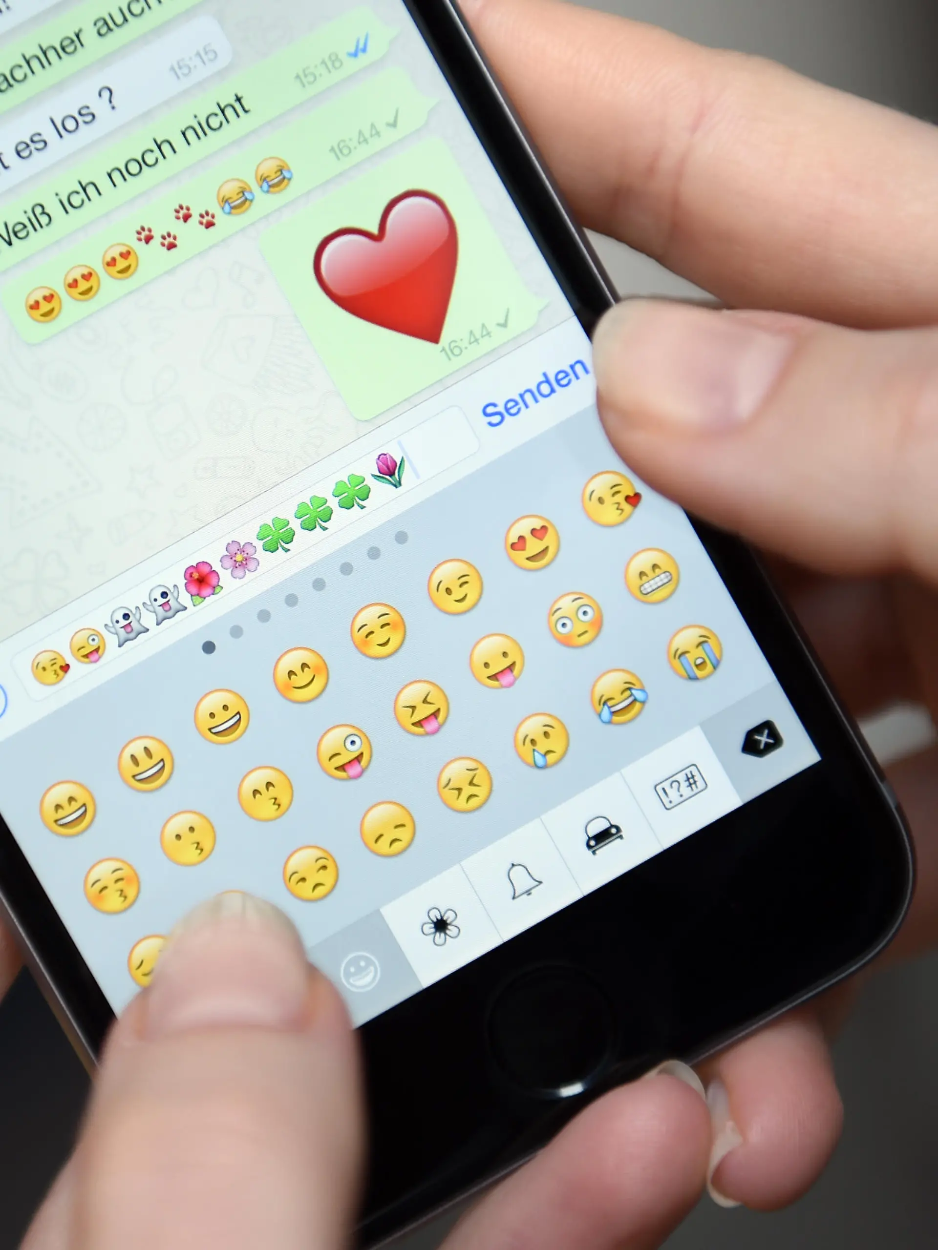 ILLUSTRATION - Auf dem Display eines iphone 6 ist am 20.03.2015 ein Chatverlauf der App 'WhatsApp' mit Emoticons zu sehen.   Foto: Britta Pedersen | Verwendung weltweit