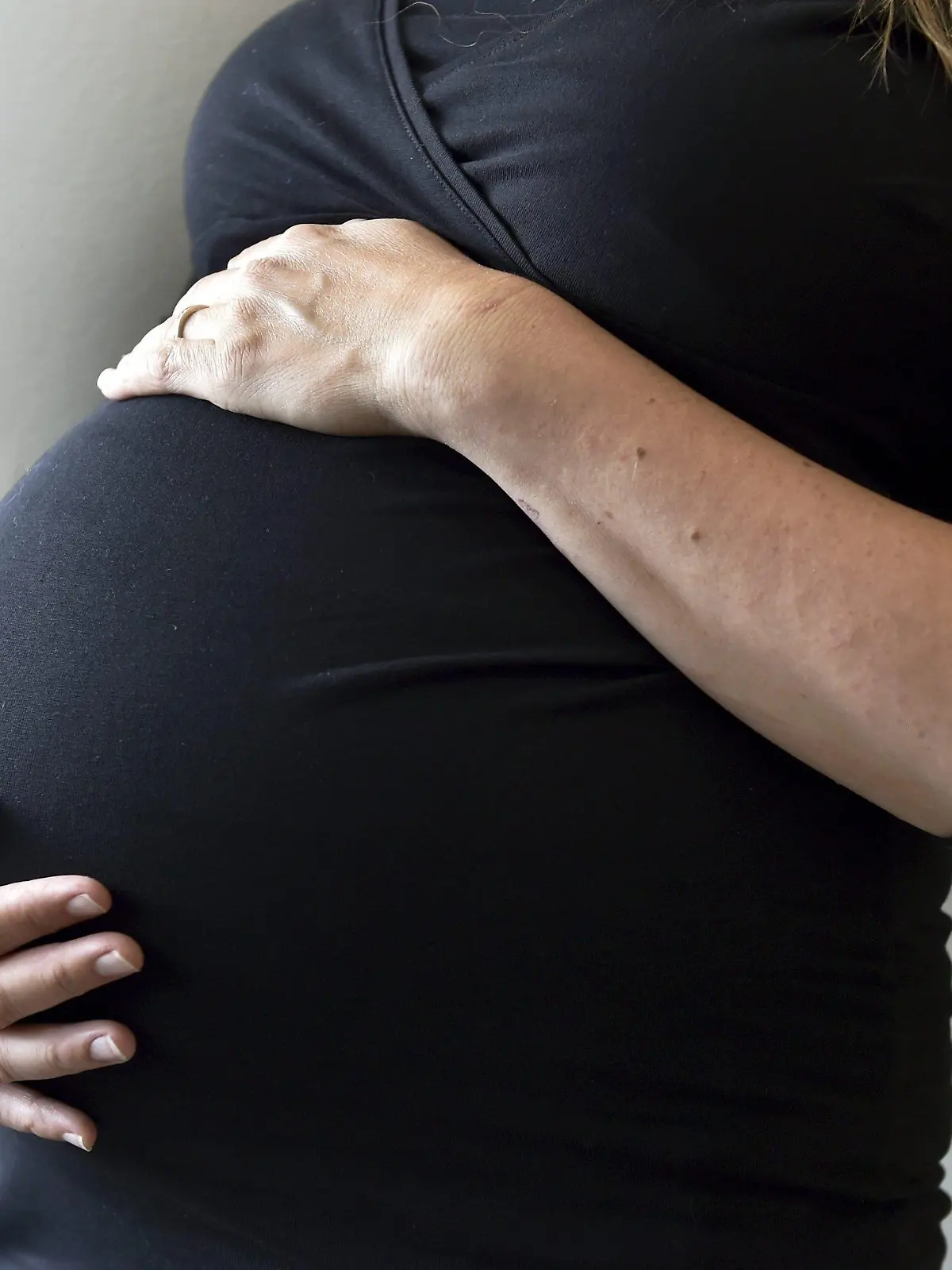 31.07.2018, Finnland, Helsinki: Eine schwangere Frau hält sich den Bauch. Foto: Emmi Korhonen/Lehtikuva/dpa +++ dpa-Bildfunk +++