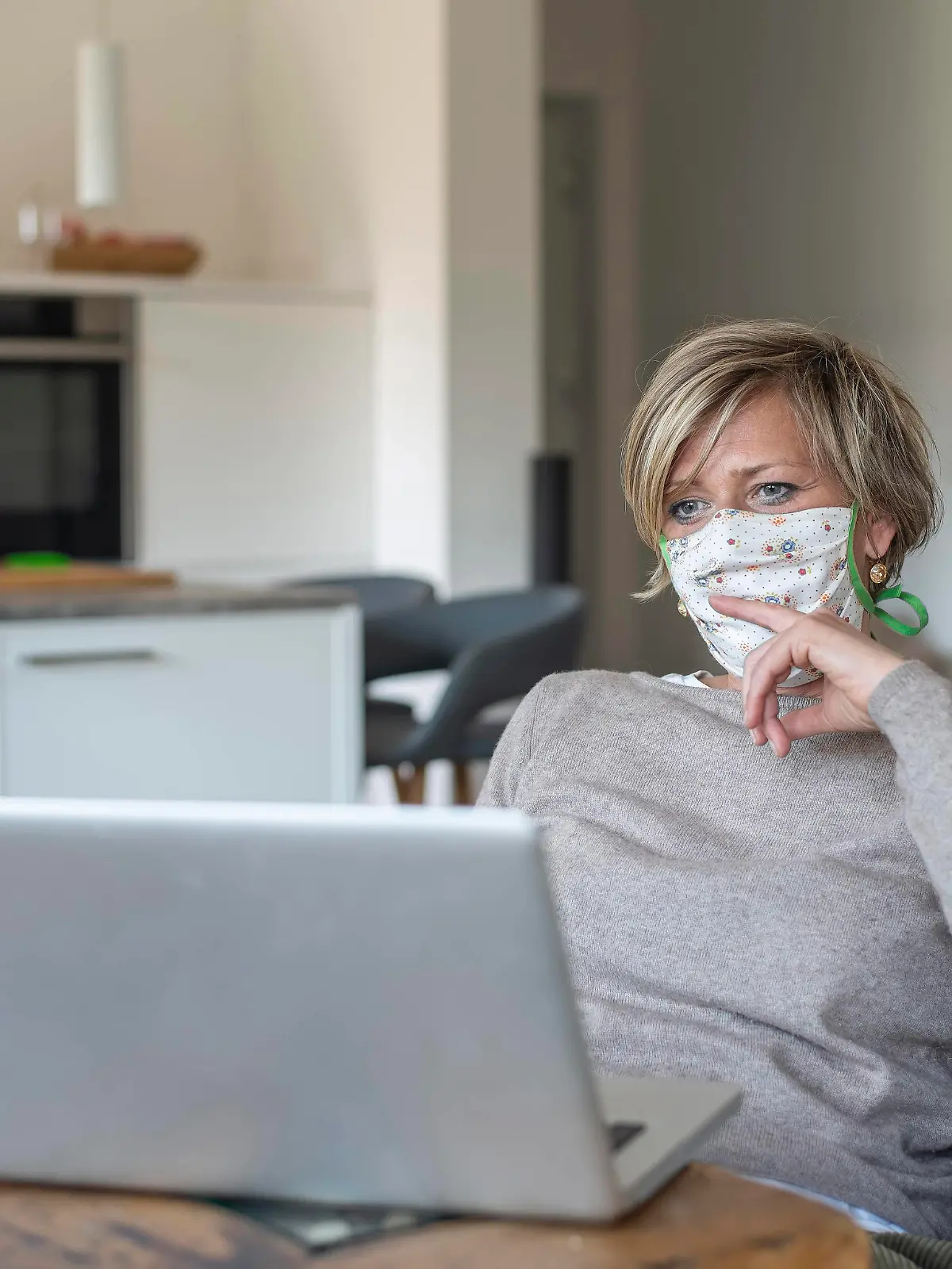  Frau mit Mundschutz arbeitet am laptop *** Woman with mouth guard working on laptop