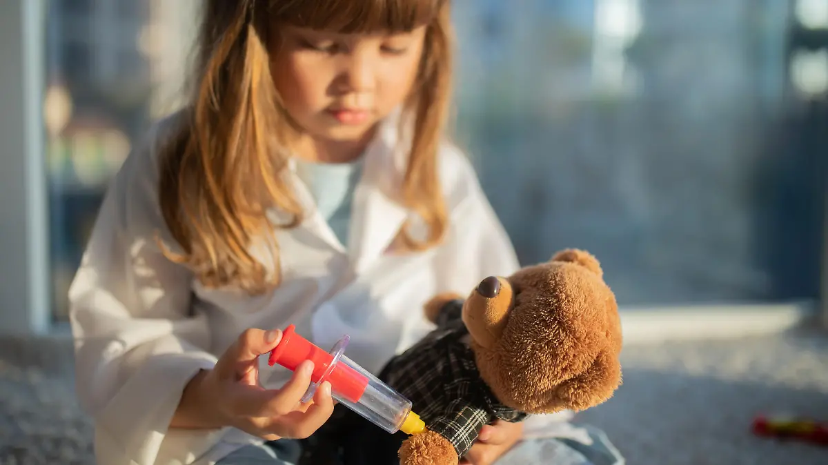 Kind impft Teddybär