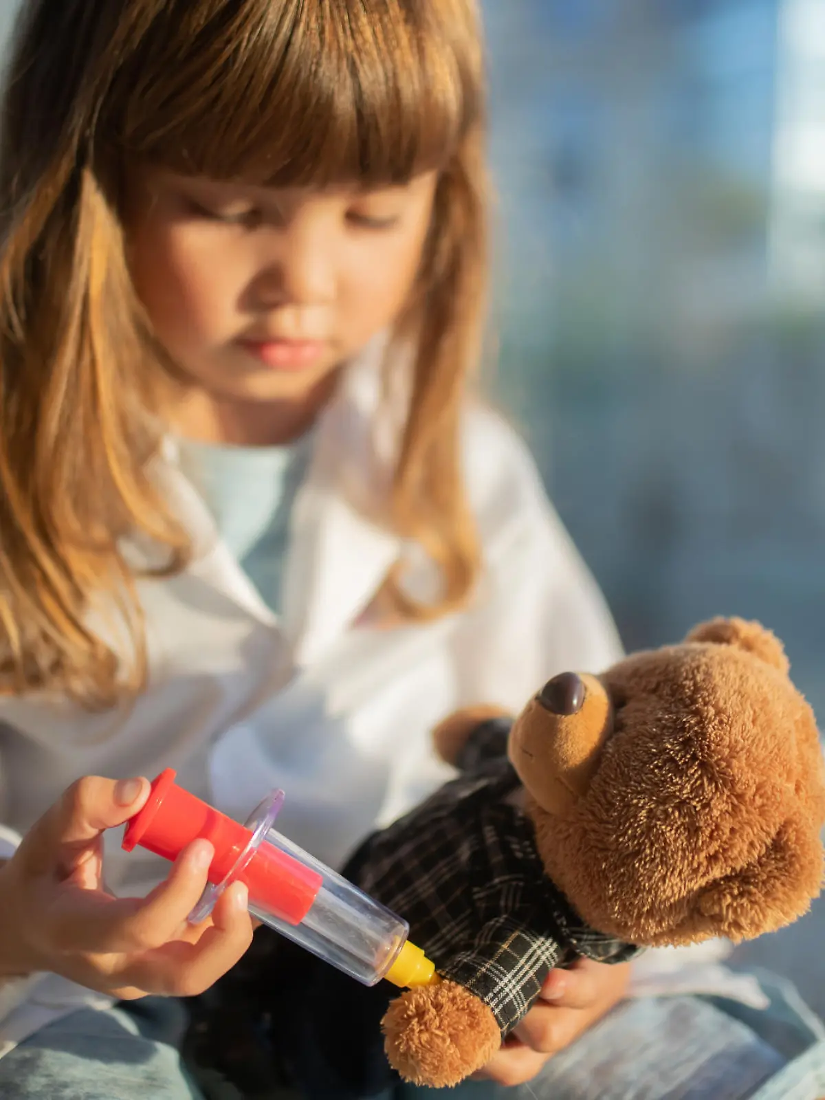 Kind impft Teddybär