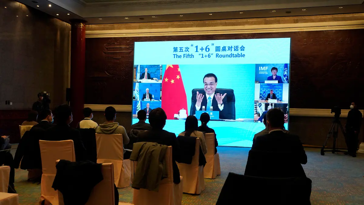 24.11.2020, China, Peking: Auf einer Leinwand spricht Li Keqiang (hinten, M), Ministerpräsident von China, während einer Videokonferenz im Rahmen des «1+6» Treffens mit führenden Mitgliedern von Unternehmen wie der Weltbank und dem Internationalen Währungsfonds. Bei dem treffen soll es um Möglichkeiten der Förderung von Erholung und Wachstum der Wirtschaft nach der Corona-Pandemie gehen. Foto: Ng Han Guan/AP/dpa +++ dpa-Bildfunk +++