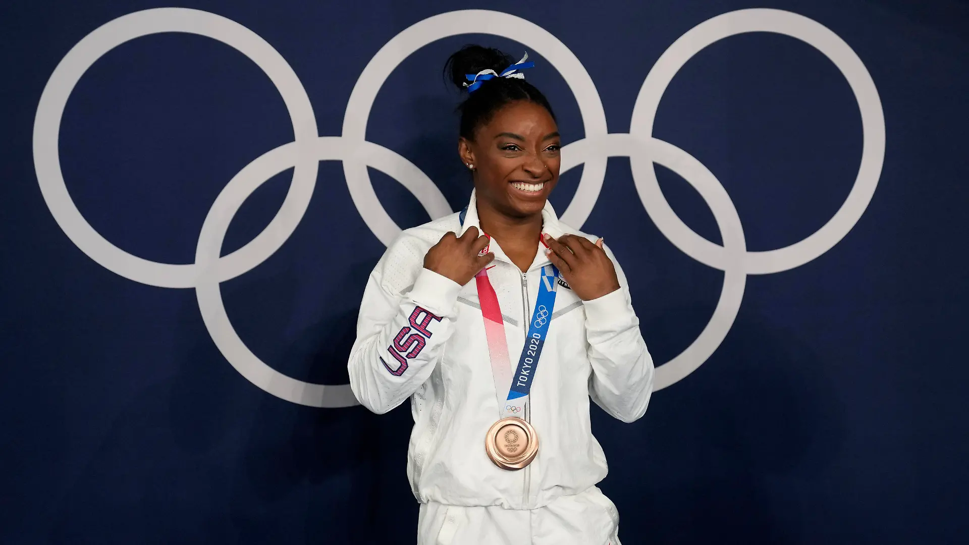 FILE - Simone Biles, of the United States, poses wearing her bronze medal from balance beam competition during artistic gymnastics at the 2020 Summer Olympics, Tuesday, Aug. 3, 2021, in Tokyo, Japan. The sport of gymnastics' international investigations agency was created in 2019 to help protect athletes after the American sexual abuse scandal. The Gymnastics Ethics Foundation has now published its strategy to set new standards in safeguarding before the 2028 Los Angeles Olympics. The “Gymnasts 2028” details goals for its work to protect athletes from harassment and abuse, investigate complaints, prosecute disciplinary cases and monitor national federations. (AP Photo/Natacha Pisarenko,File)