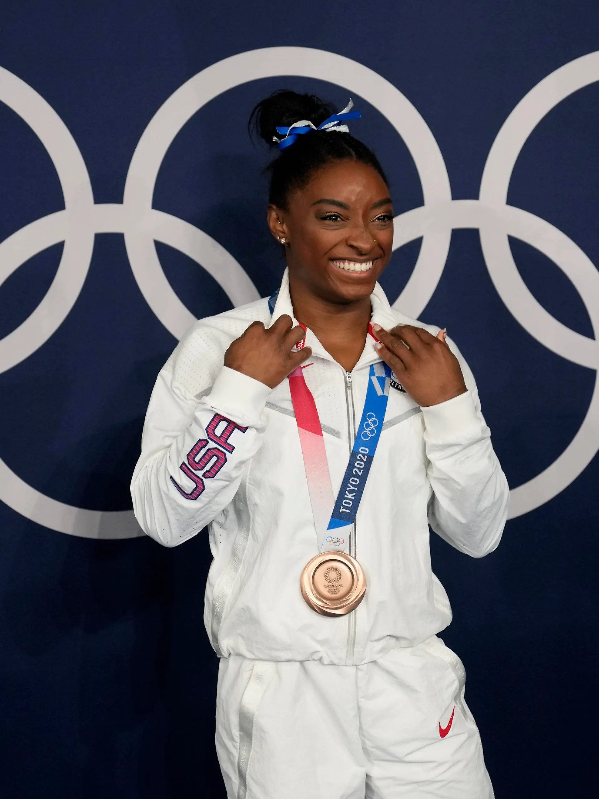 FILE - Simone Biles, of the United States, poses wearing her bronze medal from balance beam competition during artistic gymnastics at the 2020 Summer Olympics, Tuesday, Aug. 3, 2021, in Tokyo, Japan. The sport of gymnastics' international investigations agency was created in 2019 to help protect athletes after the American sexual abuse scandal. The Gymnastics Ethics Foundation has now published its strategy to set new standards in safeguarding before the 2028 Los Angeles Olympics. The “Gymnasts 2028” details goals for its work to protect athletes from harassment and abuse, investigate complaints, prosecute disciplinary cases and monitor national federations. (AP Photo/Natacha Pisarenko,File)