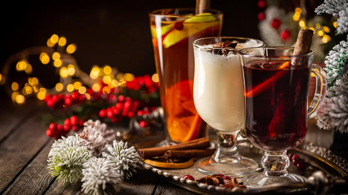 fresh yellow eggnog, grog and fruity red mulled wine with Christmas decoration. Selection of autumn or winter alcoholic hot drinks