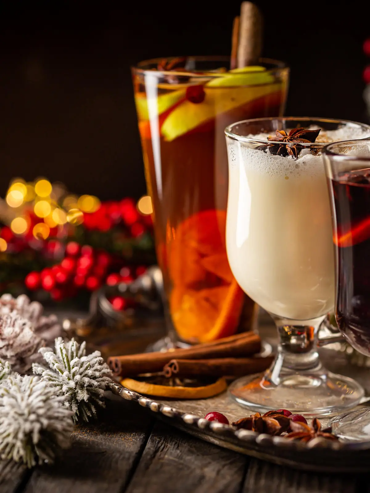 fresh yellow eggnog, grog and fruity red mulled wine with Christmas decoration. Selection of autumn or winter alcoholic hot drinks