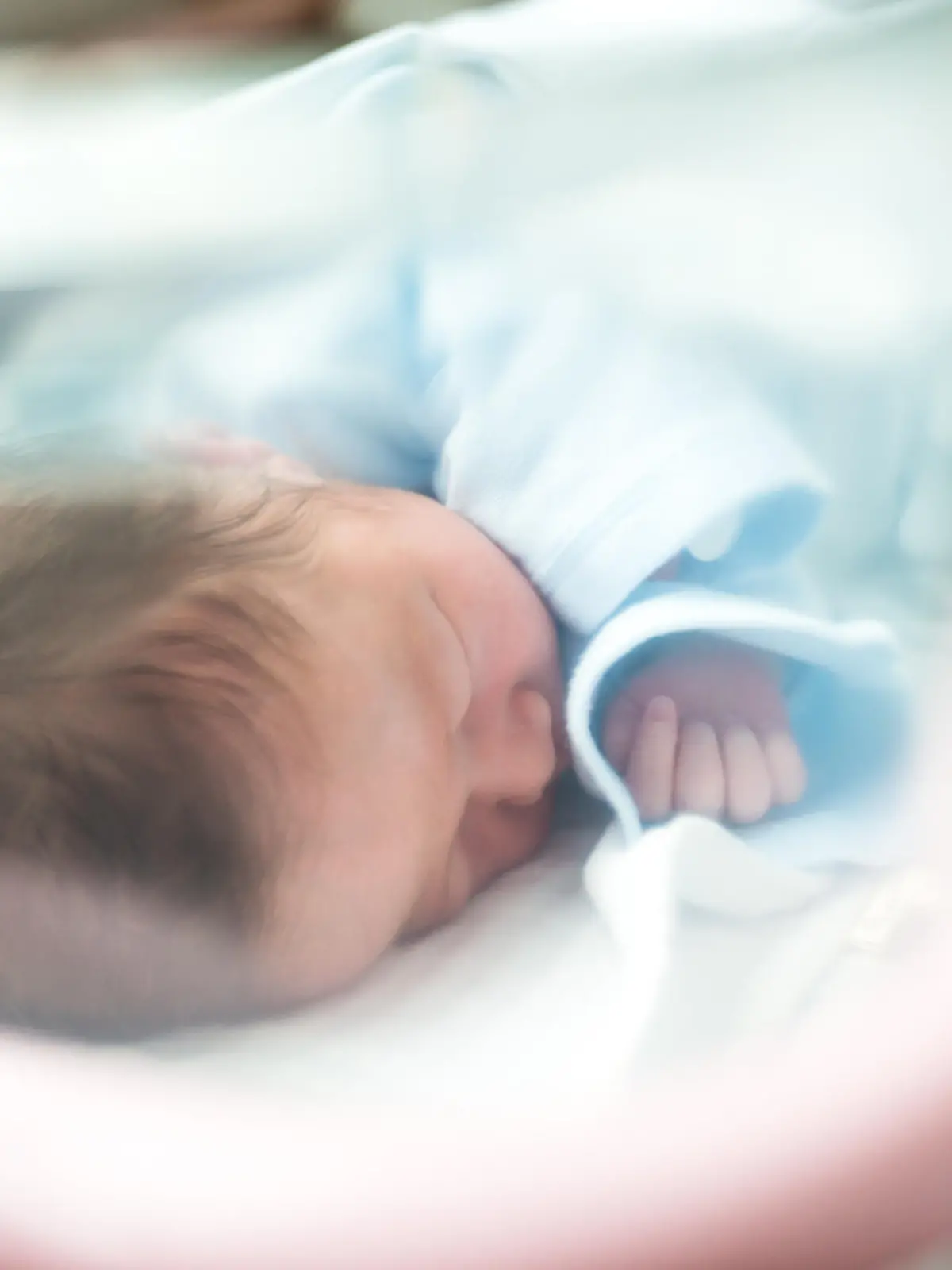 Neugeborenes Baby schläft im Krankenhausbett.