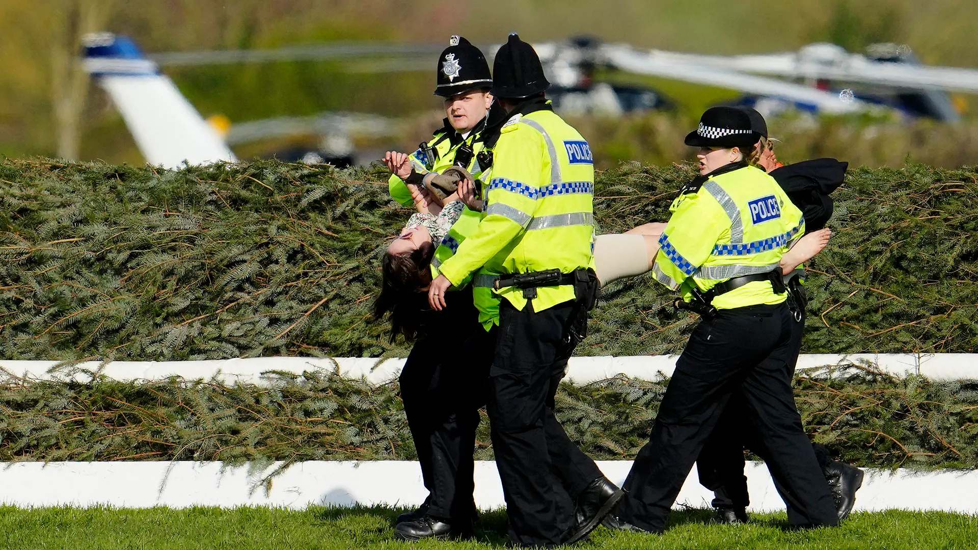 Members of the police forces remove a protester before the start of the Grand National horse race at Aintree Racecourse Liverpool, England, Saturday, April 15, 2023. The iconic Grand National race which is run over fences is 4 miles, 2 ½ furlongs has its origins in the 1839 Grand Liverpool Steeplechase.(AP Photo/Jon Super)