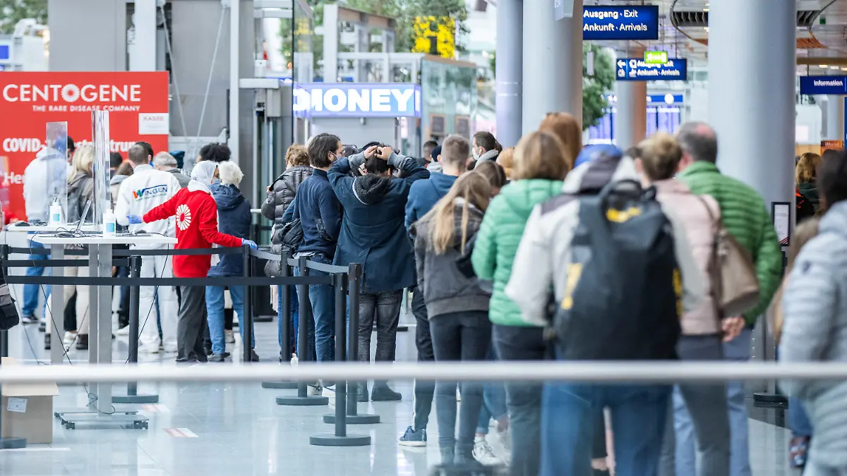 15.10.2020, Nordrhein-Westfalen, Düsseldorf: Zahlreiche Menschen warten in langen Schlangen im Flughafen-Terminal vor dem Walk-In-Zentrum des Unternehmens Centogene auf einen Covid-19-Test. Das Zentrum bietet eine weitere Test-Möglichkeit für Reisende und alle Düsseldorfer. Das zweite Testzentrum befindet sich im Unterschied zum ersten Testzentrum nicht im Sicherheitsbereich, sondern im frei zugänglichen, öffentlichen Bereich des Flughafens. Foto: Marcel Kusch/dpa +++ dpa-Bildfunk +++