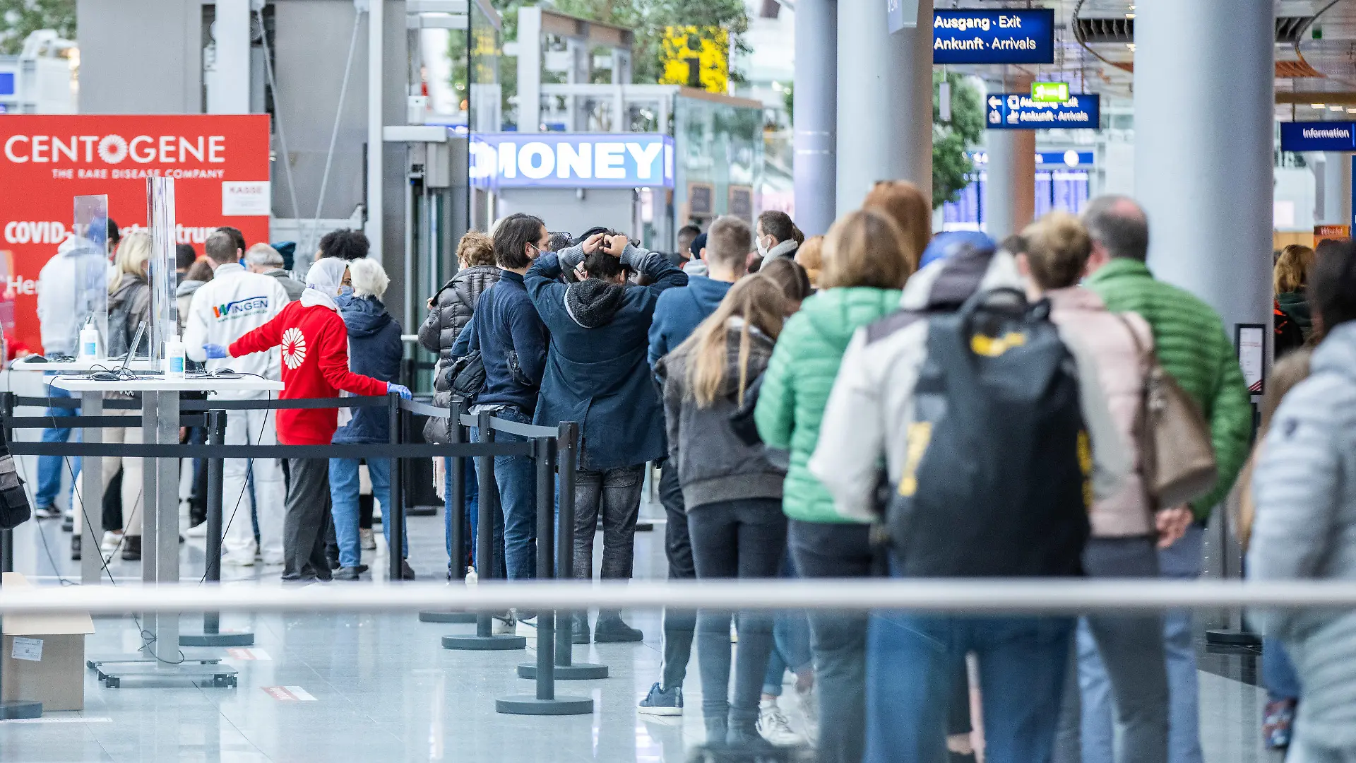 15.10.2020, Nordrhein-Westfalen, Düsseldorf: Zahlreiche Menschen warten in langen Schlangen im Flughafen-Terminal vor dem Walk-In-Zentrum des Unternehmens Centogene auf einen Covid-19-Test. Das Zentrum bietet eine weitere Test-Möglichkeit für Reisende und alle Düsseldorfer. Das zweite Testzentrum befindet sich im Unterschied zum ersten Testzentrum nicht im Sicherheitsbereich, sondern im frei zugänglichen, öffentlichen Bereich des Flughafens. Foto: Marcel Kusch/dpa +++ dpa-Bildfunk +++