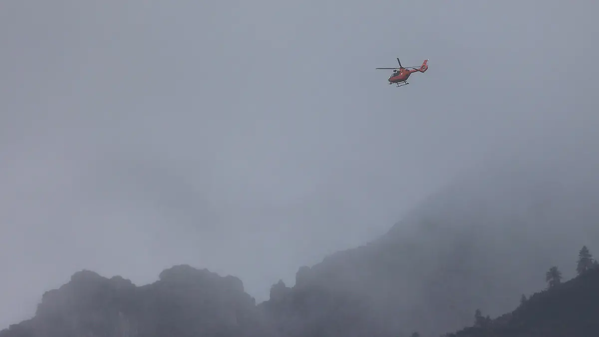HANDOUT - 17.09.2022, Bayern, Ramsau: Mit einem Hubschrauber suchen Rettungskräfte der Bergwacht bei Berchtesgaden am Hochkalter nach einem vermissten Wanderer. Der 24-Jährige war am Samstag (17.09.2022) bei Schneefall zu einer hochalpinen Tour aufgebrochen, war gestürzt und hatte die Rettungskräfte alarmiert. (zu dpa: «Suche nach verunglücktem Bergsteiger weiterhin erfolglos») Foto: -/Bergwacht Ramsau/dpa +++ dpa-Bildfunk +++