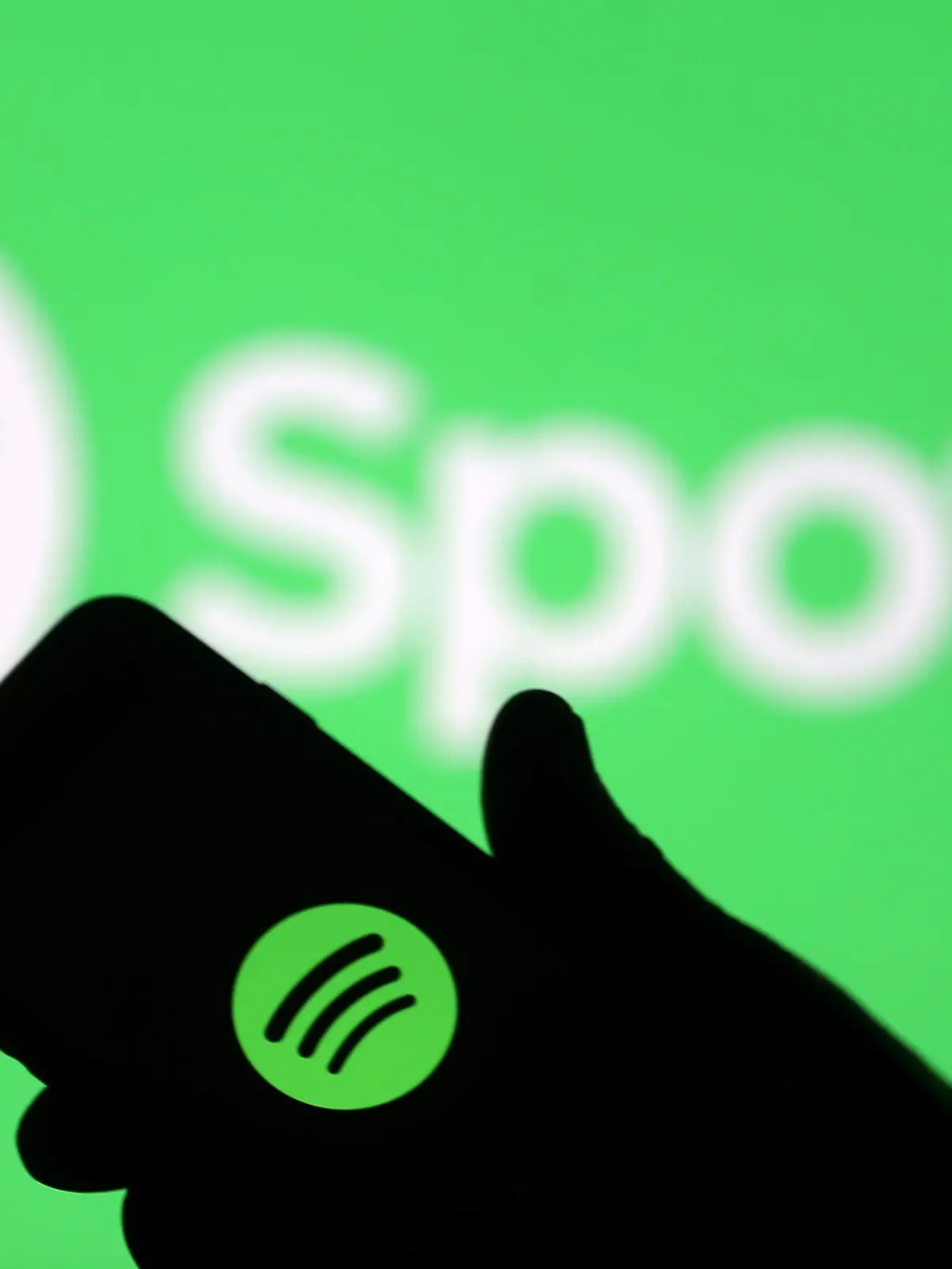 FILE PHOTO: A smartphone is seen in front of a screen projection of Spotify logo, in this picture illustration taken April 1, 2018. REUTERS/Dado Ruvic/Illustration/File Photo  GLOBAL BUSINESS WEEK AHEAD