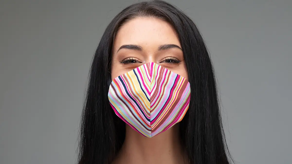 Junge Frau mit Maske schaut freundlich