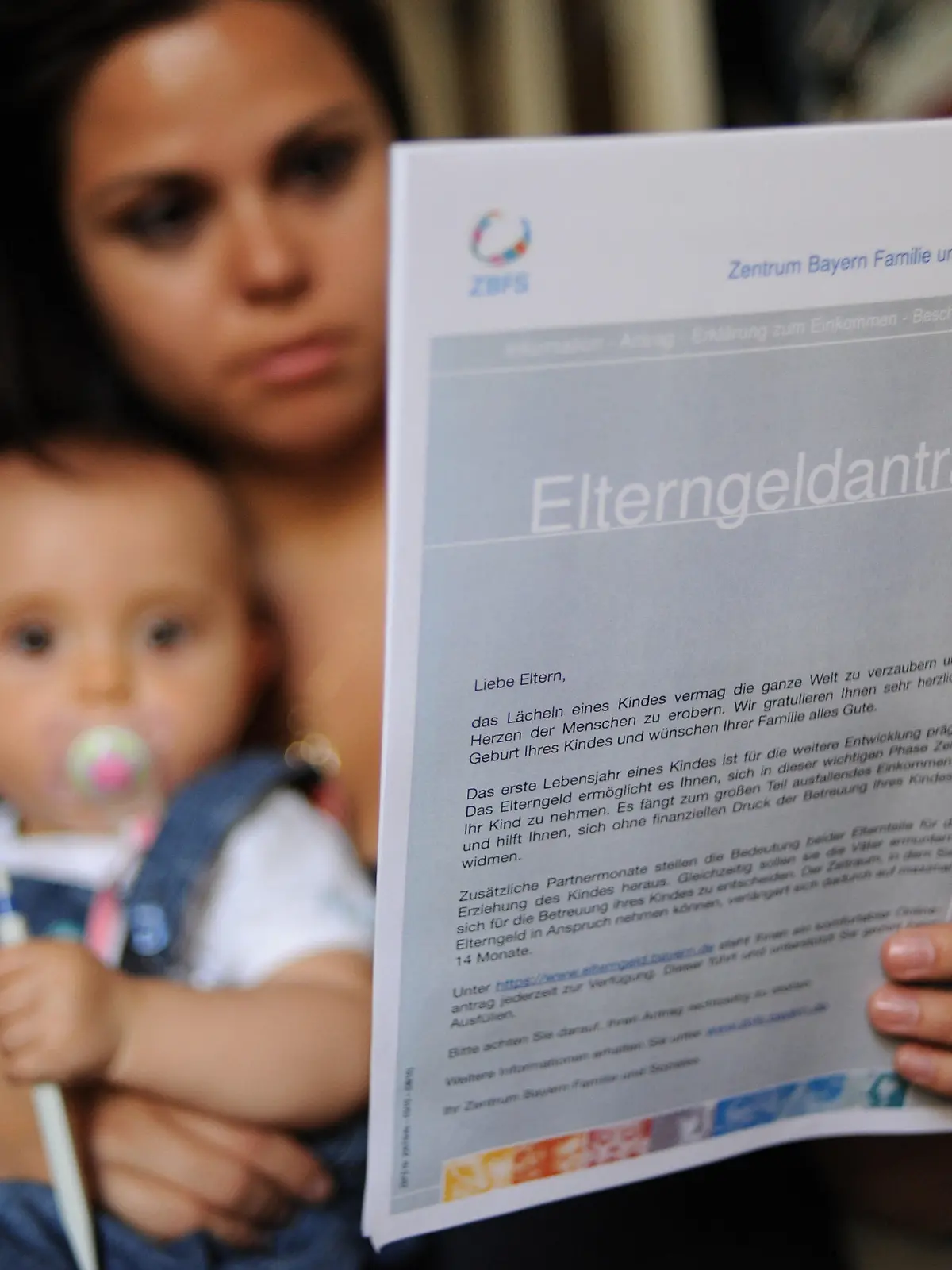 ARCHIV - Eine Frau sitzt mit ihrer acht Monate alten Tochter in ihrer Wohnung in München (Oberbayern) und hält ein Formular zur Beantragung von Elterngeld in der Hand (Archivfoto vom 10.06.2010). Das Statistische Bundesamt veröffentlicht am Dienstag (03.08.2010) Zahlen und Entwicklungen zum Thema Elterngeld im Zeitraum von Januar 2008 bis März 2010. Die Zahlen beziehen sich auf alle 2008 geborenen Kinder, für die 14 Monate lang Elterngeld beantragt werden kann. Foto: Andreas Gebert dpa  +++(c) dpa - Bildfunk+++