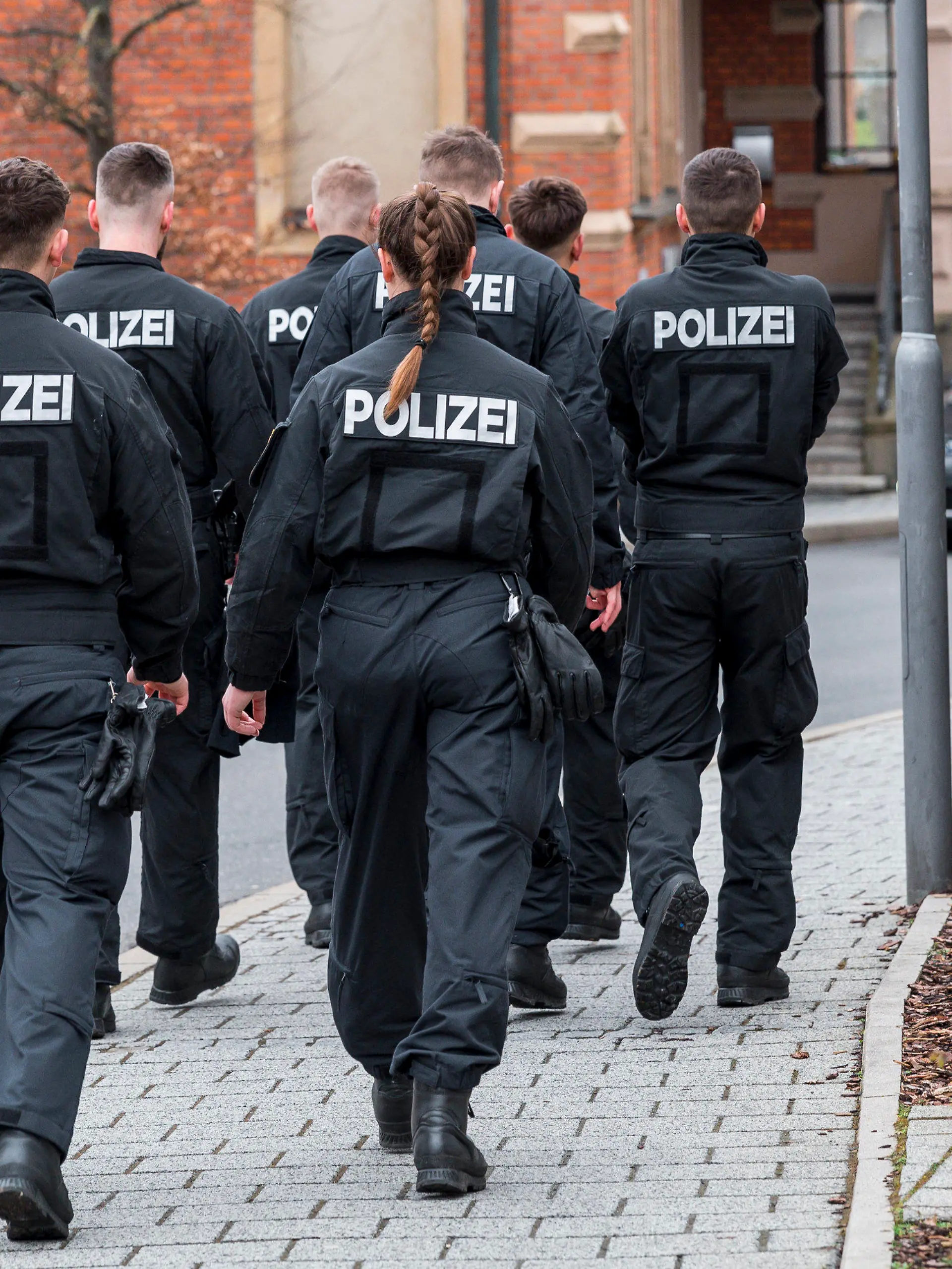 13.03.2023, Bayern, Lichtenfels: Mehrere Einsatzkräfte der Polizei gehen das Gebiet um das Blumengeschäft ab, in dem am Freitagabend eine leblose Frau aufgefunden wurde. Foto: Daniel Vogl/dpa +++ dpa-Bildfunk +++