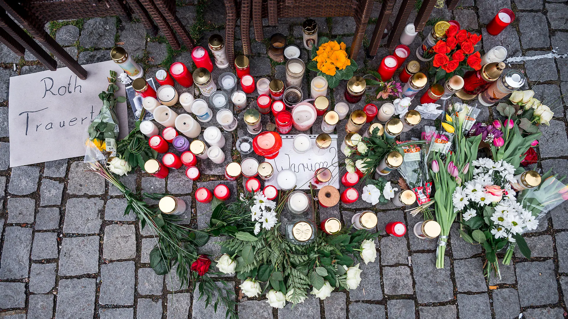 13.03.2023, Bayern, Lichtenfels: Auf dem Platz vor dem Blumengeschäft, in dem am 10. März eine leblose Frau aufgefunden wurde, sind wenig später Blumen und Kerzen niedergelegt. Spaziergänger hatten die tote 50-Jährige in dem Blumenladen in der Lichtenfelser Innenstadt entdeckt. Am 24. März nahm die Polizei einen Tatverdächtigen fest. (zu dpa «Blumenverkäuferin getötet - 17-jähriger Tatverdächtiger gefasst) Foto: Daniel Vogl/dpa +++ dpa-Bildfunk +++