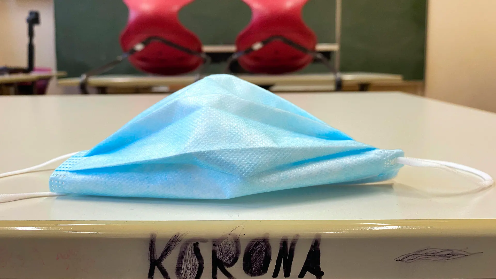 leeres Klassenzimmer, aufgestuhlt, Mundschutzmaske und Schriftzug KORONA auf Tisch, Einzeltische ohne Abstandsregel, Corona-Krise, Deutschland Leeres Klassenzimmer Corona-Krise *** Empty classroom, seated, face mask and lettering KORONA on table, single tables without distance rule, Corona crisis, Germany Empty classroom Corona crisis