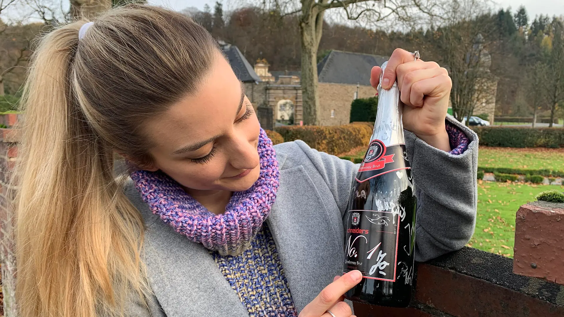 Redakteurin Daria Bücheler mit einer Flasche Chardonnay aus dem Bistro Schneiders.