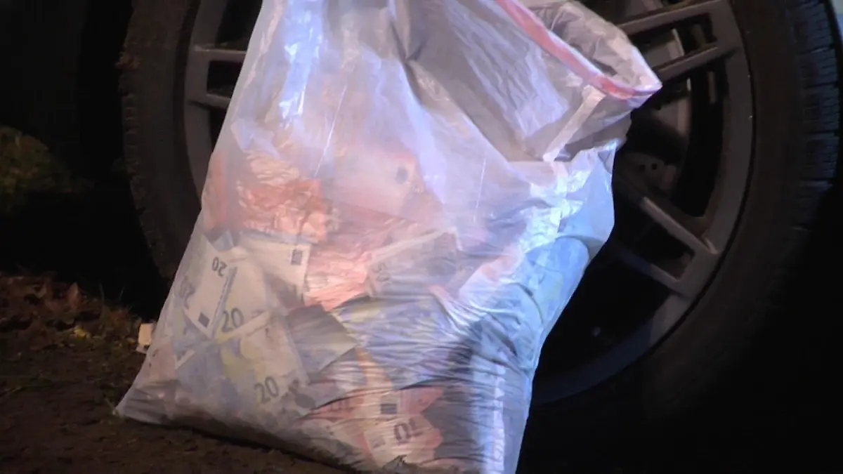Eine Tüte mit Bargeld aus einem Geldautomaten-Überfall steht am 09.03.2016 in Meppen (Niedersachsen) neben einem verunglückten Fahrzeug. Nach der Sprengung eines Geldautomaten in der Meppener Innenstadt sind die drei Räuber mit ihrem Fluchtwagen verunglückt. Ein Mann starb bei dem Unfall, ein weiterer wurde verletzt. Ein flüchtiger dritter Täter konnte festgenommen werden. Foto Nord-West-Media TV/dpa (zu dpa "Räuber verunglückt nach Geldautomaten-Sprengung tödlich" vom 09.03.2016) ++