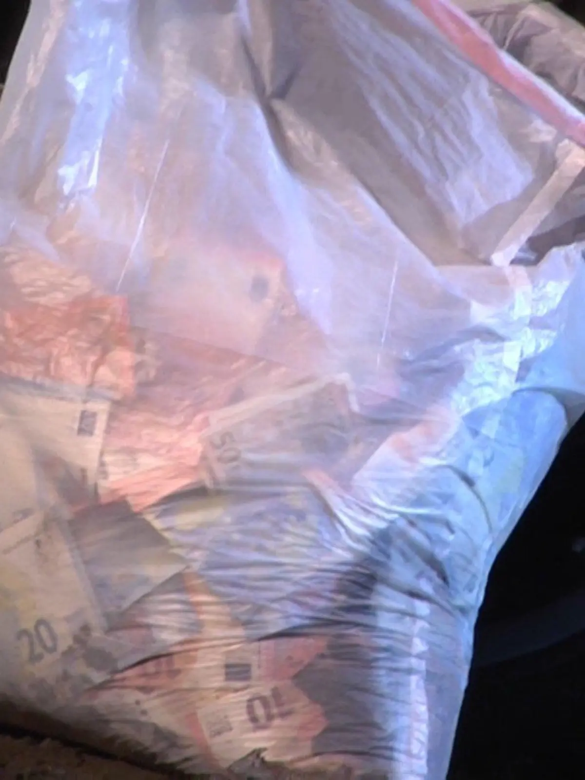 Eine Tüte mit Bargeld aus einem Geldautomaten-Überfall steht am 09.03.2016 in Meppen (Niedersachsen) neben einem verunglückten Fahrzeug. Nach der Sprengung eines Geldautomaten in der Meppener Innenstadt sind die drei Räuber mit ihrem Fluchtwagen verunglückt. Ein Mann starb bei dem Unfall, ein weiterer wurde verletzt. Ein flüchtiger dritter Täter konnte festgenommen werden. Foto Nord-West-Media TV/dpa (zu dpa "Räuber verunglückt nach Geldautomaten-Sprengung tödlich" vom 09.03.2016) ++