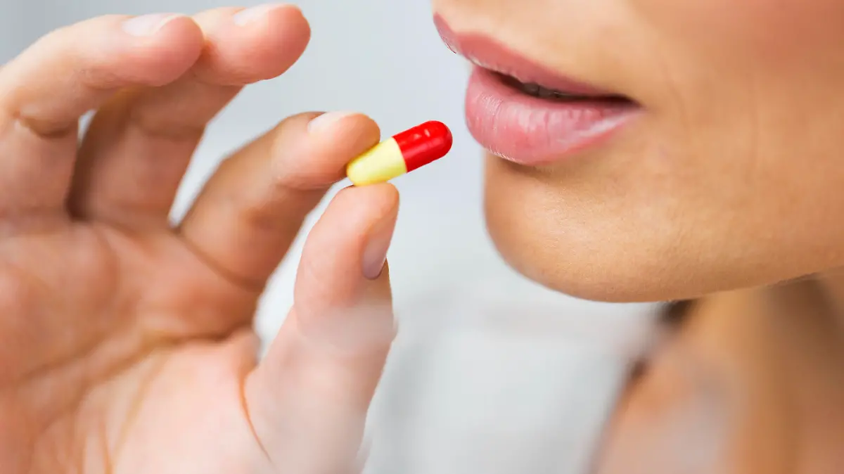 medicine, health care and people concept - close up of woman taking in pill