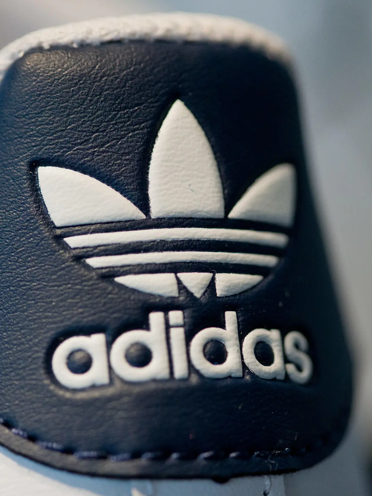 ARCHIV - 03.03.2016, Bayern, Herzogenaurach: Das Logo des Sportartikelherstellers Adidas auf einem Schuh. (zu dpa: "Adidas löst KfW-Kredit ab und sichert sich frisches Geld") Foto: picture alliance / Daniel Karmann/dpa +++ dpa-Bildfunk +++