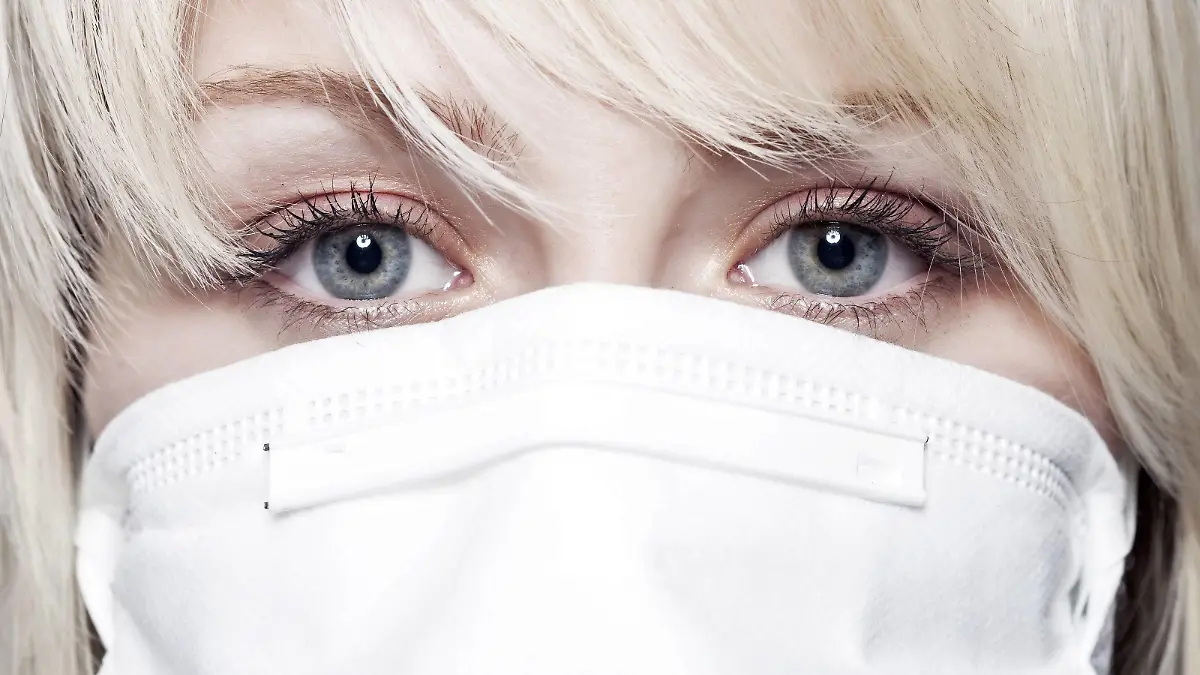  Junge Frau mit Mundschutz. Junge Frau mit Mundschutz.  MR - model released