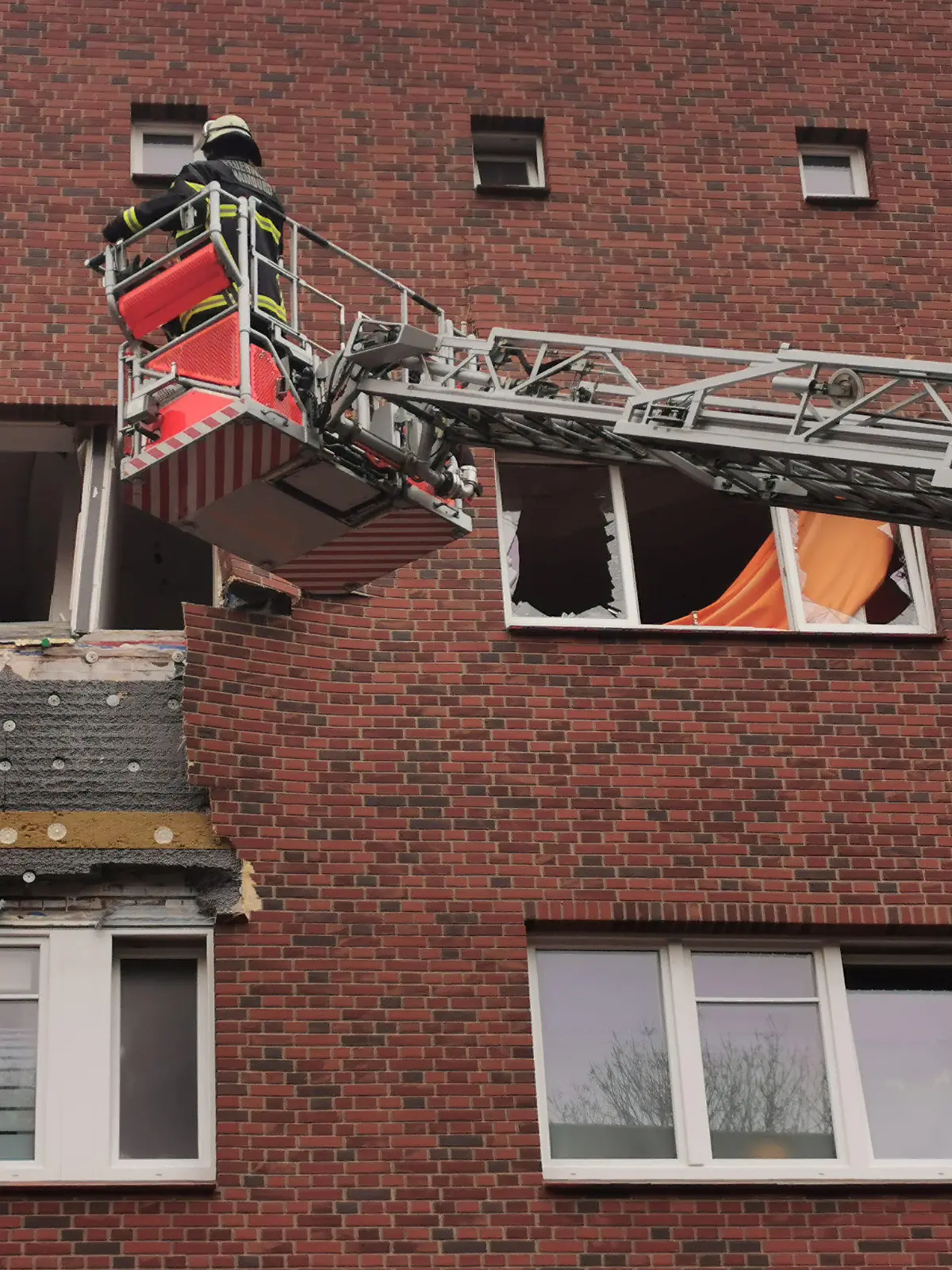 16.11.2020, Hamburg: Einsatzkräfte der Feuerwehr begutachten nach einer Explosion eine Wohnung in einem Mehrfamilienhaus im Hamburger Stadtteil Barmbek-Nord. Bei der Explosion sei ein Mensch verletzt worden, sagte ein Feuerwehrsprecher. Die Fenster der Wohnung in einem Obergeschoss seien zerborsten und Fassadenteile beschädigt worden. Ein Feuer habe es nach ersten Erkenntnissen nicht gegeben. Foto: Tnn/dpa +++ dpa-Bildfunk +++