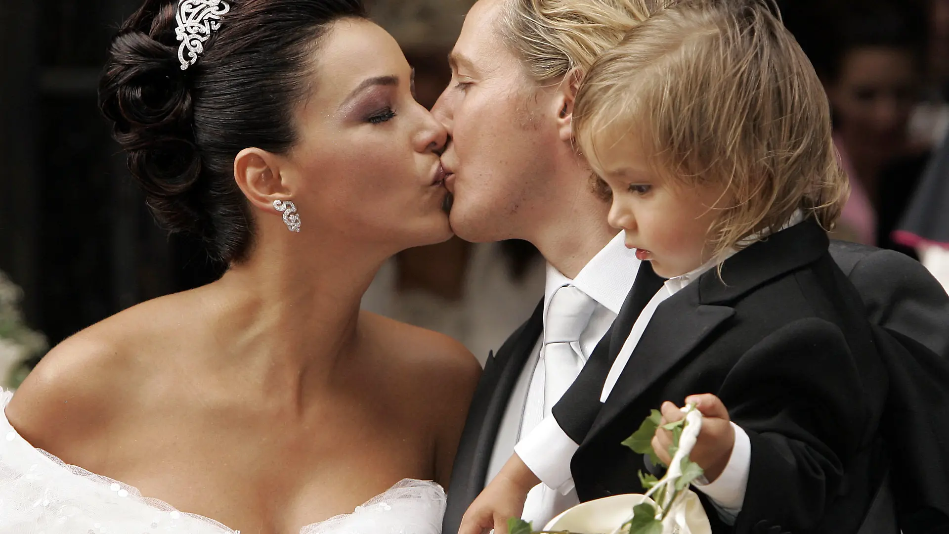 Werbestar Verona Pooth und ihr Ehemann Franjo küssen sich am Samstag (10.09.2005) nach der Trauung vor dem Stephansdom in Wien. Franjo hält dabei Sohn San Diego im Arm. Das Paar hatte am 18.05.2004 in San Diego standesamtlich geheiratet und feiert nun mit 300 geladenen Gästen die kirchliche Trauung. Foto: Jörg Carstensen dpa +++(c) dpa - Bildfunk+++