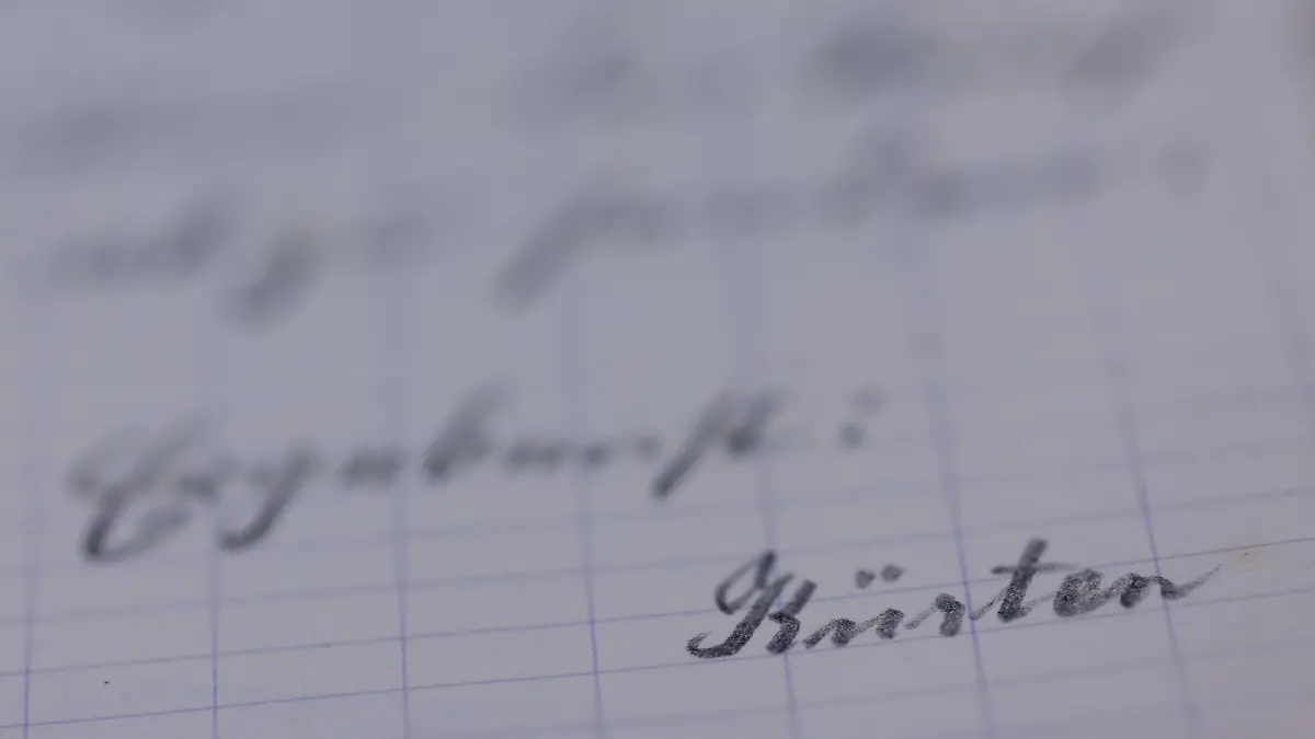 12.04.2023, Nordrhein-Westfalen, Düsseldorf: Unterlagen - hier ein unterschriebener Brief von Kürten - aus der Handakte zum Kriminalfall Peter Kürten liegen im Stadtarchiv auf einem Tisch. Die Handakte soll an die Abteilung Rheinland im Landesarchiv übergeben werden. Kürten war einer der meistgesuchten Serienmörder der Weimarer Republik. Allein in Düsseldorf hatte der in den Jahren 1929/30 acht Menschen getötet. Nach seiner Verhaftung hatte der Untersuchungsrichter die Handakte mit den aus seiner Sicht wichtigsten Informationen zum Fall angelegt. Foto: Rolf Vennenbernd/dpa - ACHTUNG: Nur zur redaktionellen Verwendung im Zusammenhang mit einer Berichterstattung und nur mit vollständiger Nennung des vorstehenden Credits +++ dpa-Bildfunk +++
